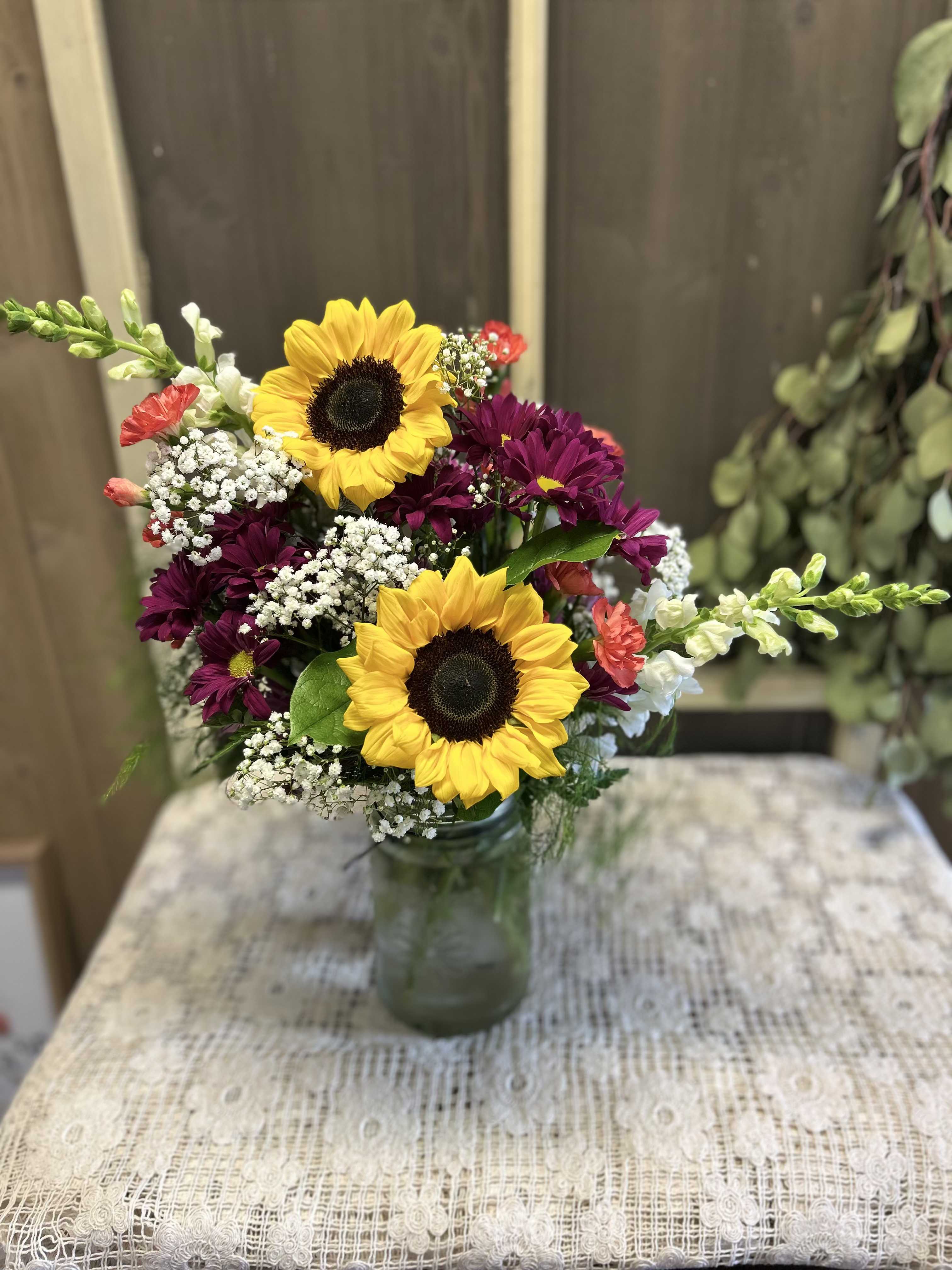 Sunny Days - The colorful arrangement gives a bold statement sunflowers leading the way.    Approximate height 18"