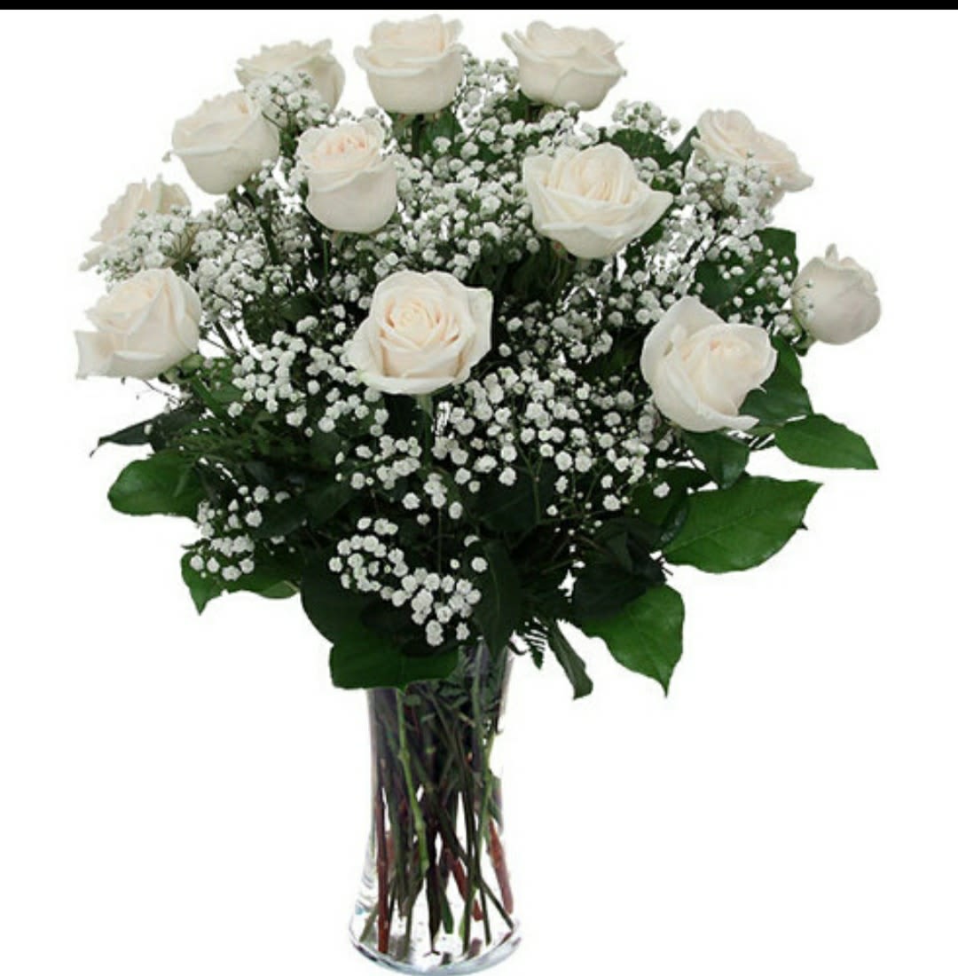 White roses and baby's breath in a clear glass vase
