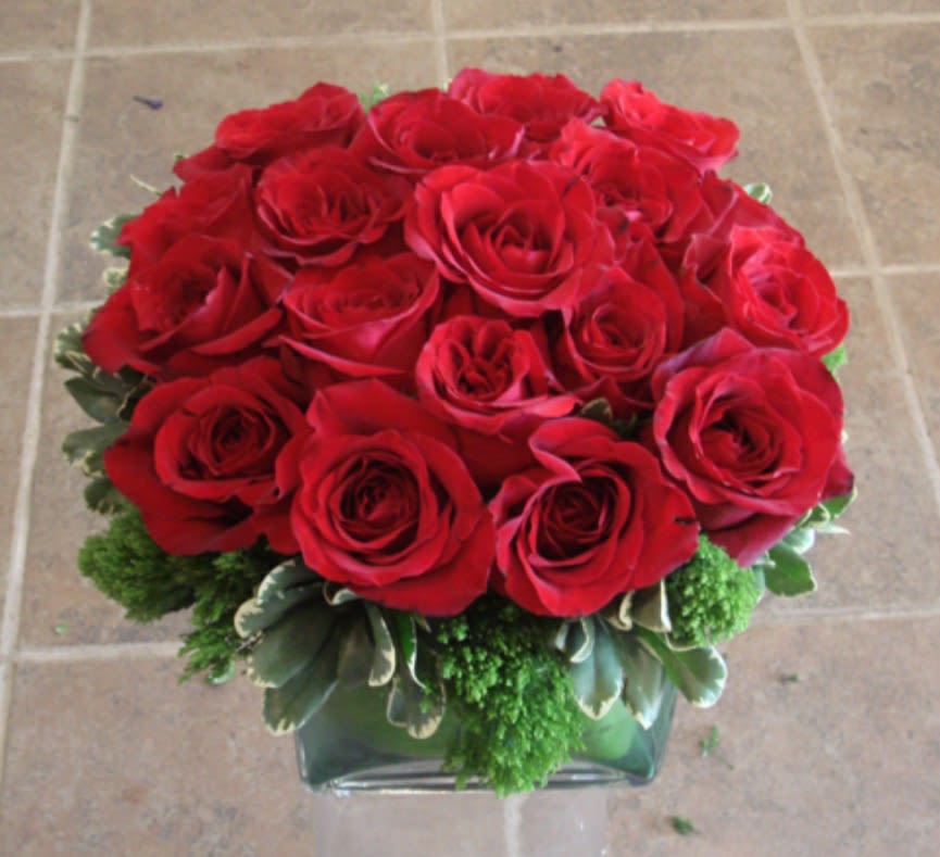 Red roses arranged in a low glass vase