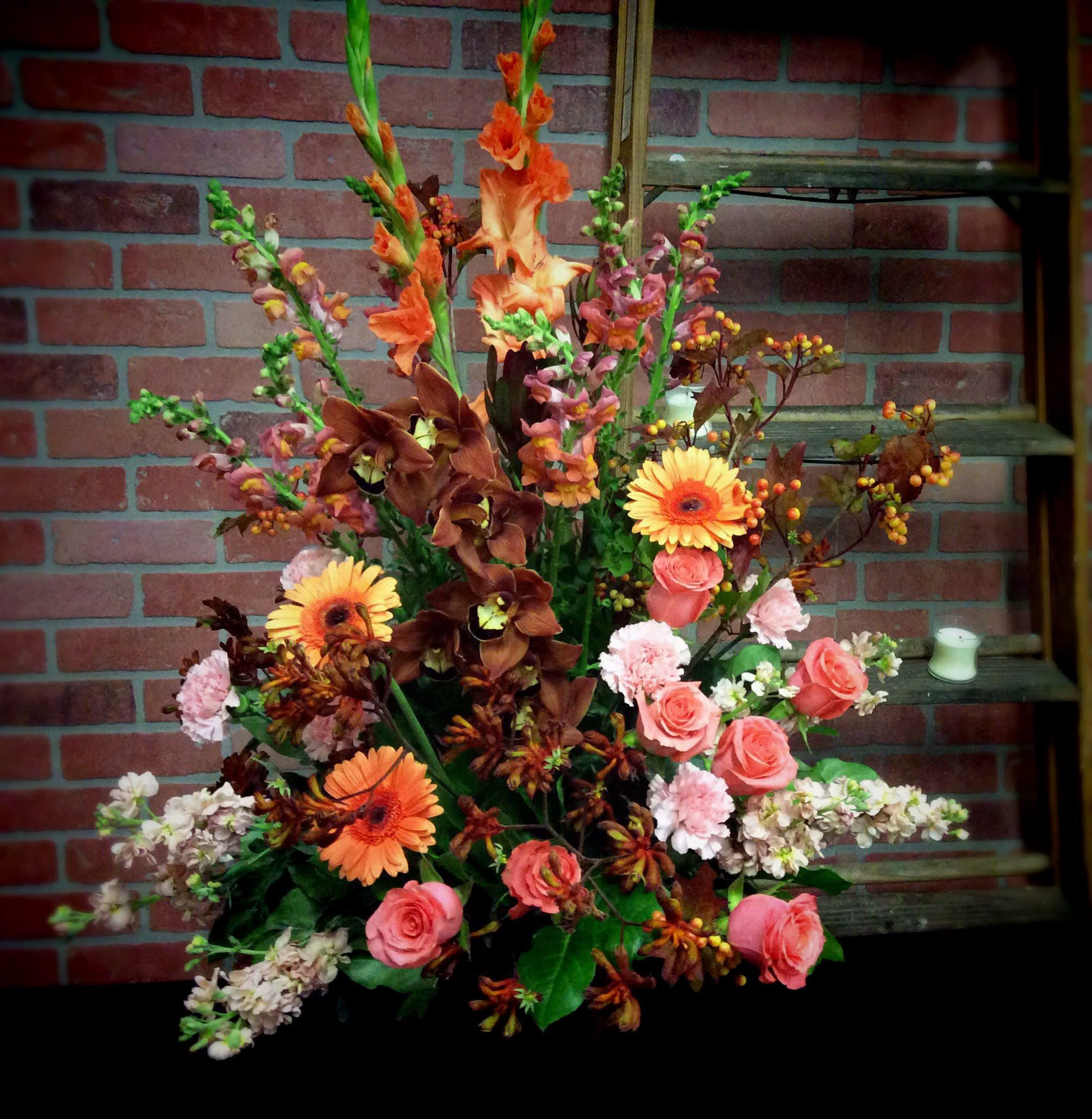 Tall mixed floral arrangement with orange, pink, and white blooms