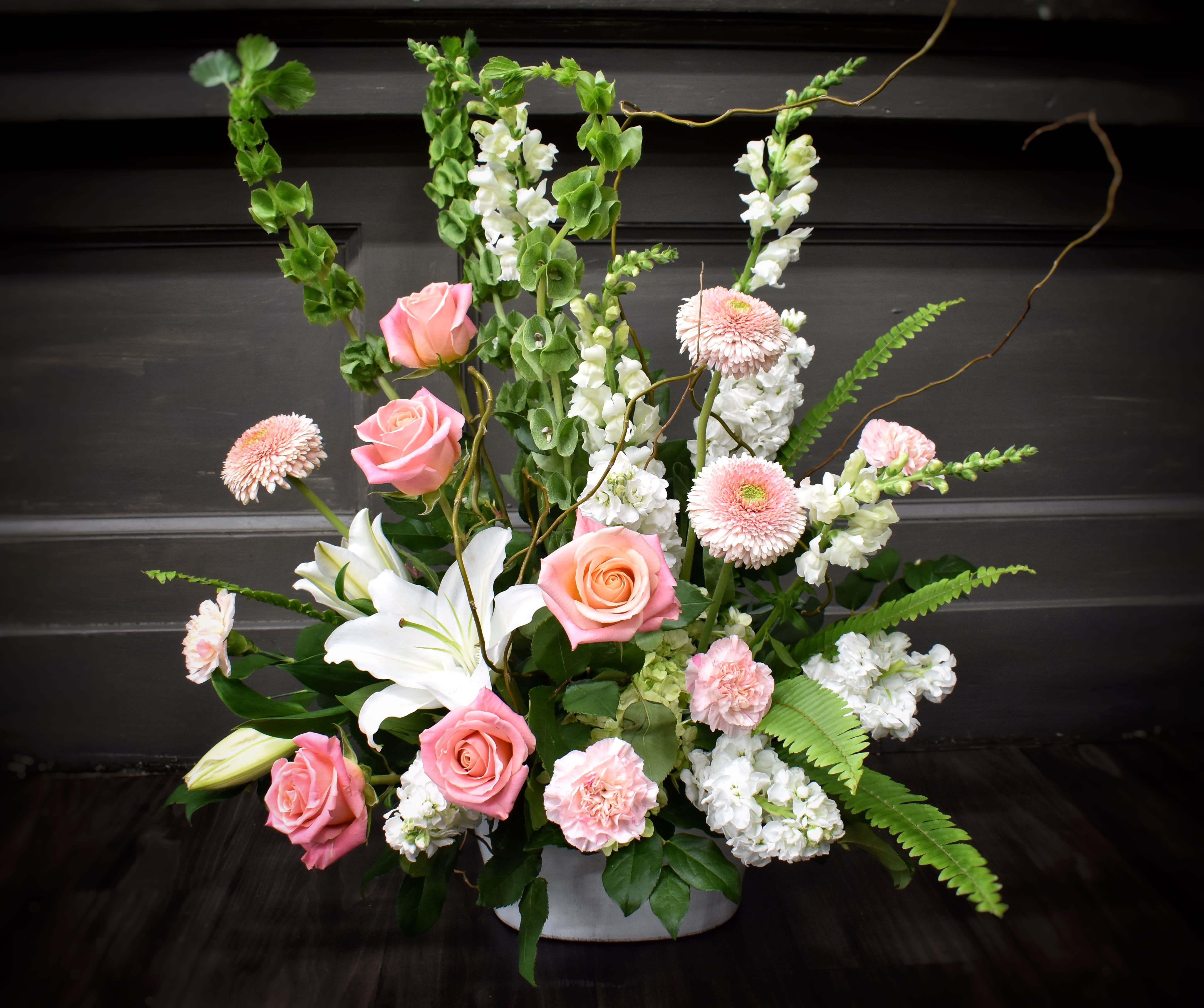 Pink roses and white lilies in a low white container