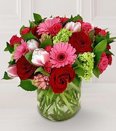 Bouquet of red and pink flowers in a clear glass vase