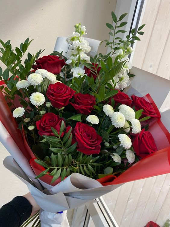 Bouquet of red roses and white flowers wrapped in red and gray paper