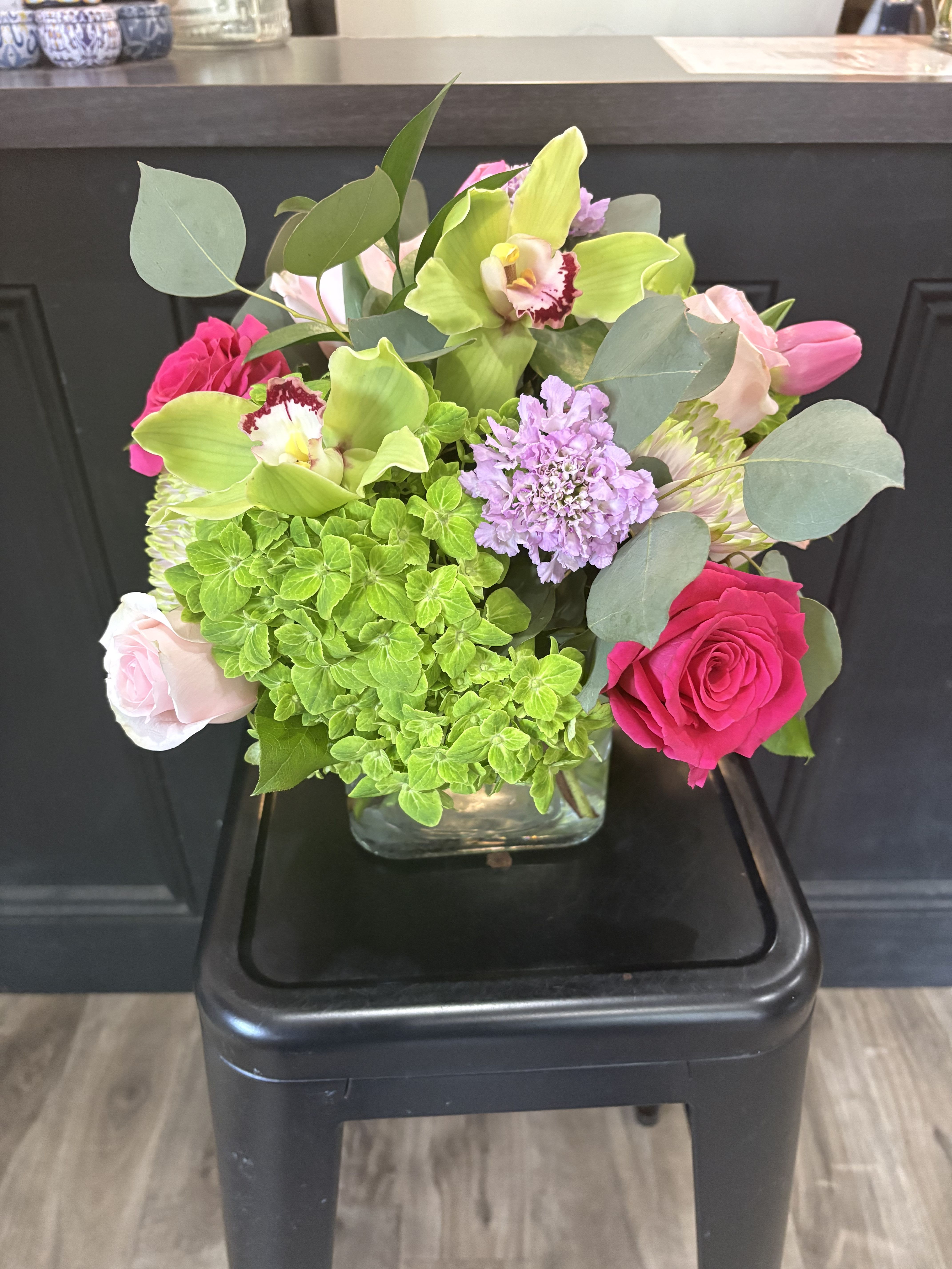 Emma - A stunning combination of hydrangeas, roses, tulips, scabiosa, cymbidum orchid and cremone with eucalyptus greenery.  Delivery minimum is $50.00 Our DELIVERY SERVICE IS TILL 3 PM We cannot guarantee requests for a specific time of delivery. There might be flower substitutions, due to low supply of certain flowers. However, we do our best to provide you with the same look and feel of the arrangement. Our main goal is to always give our customers quality flowers and service. To make sure that you get the exact same flowers, ordering a few days ahead of desired delivery date is key.