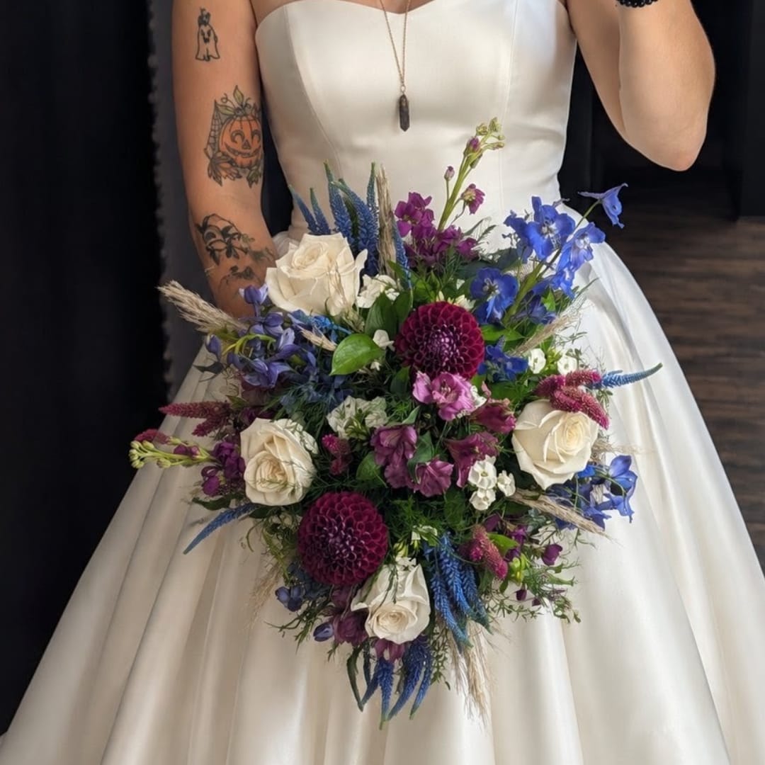 Bride holding a bouquet of white, blue, and purple flowers