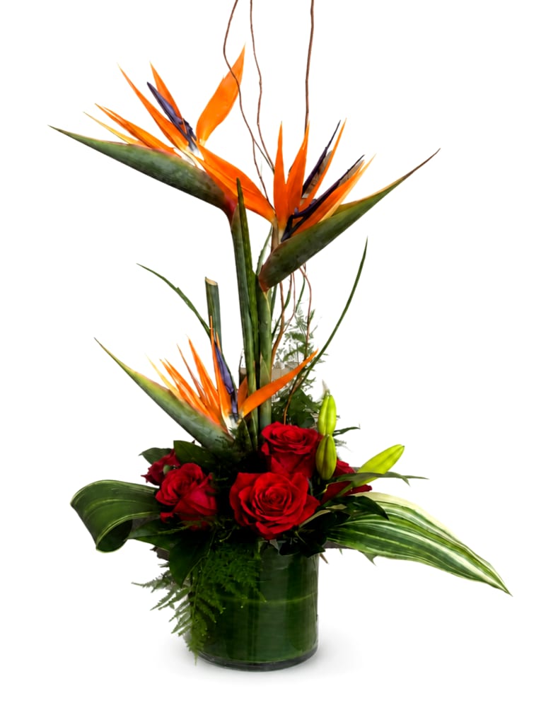 Tall tropical arrangement with red roses in a glass vase