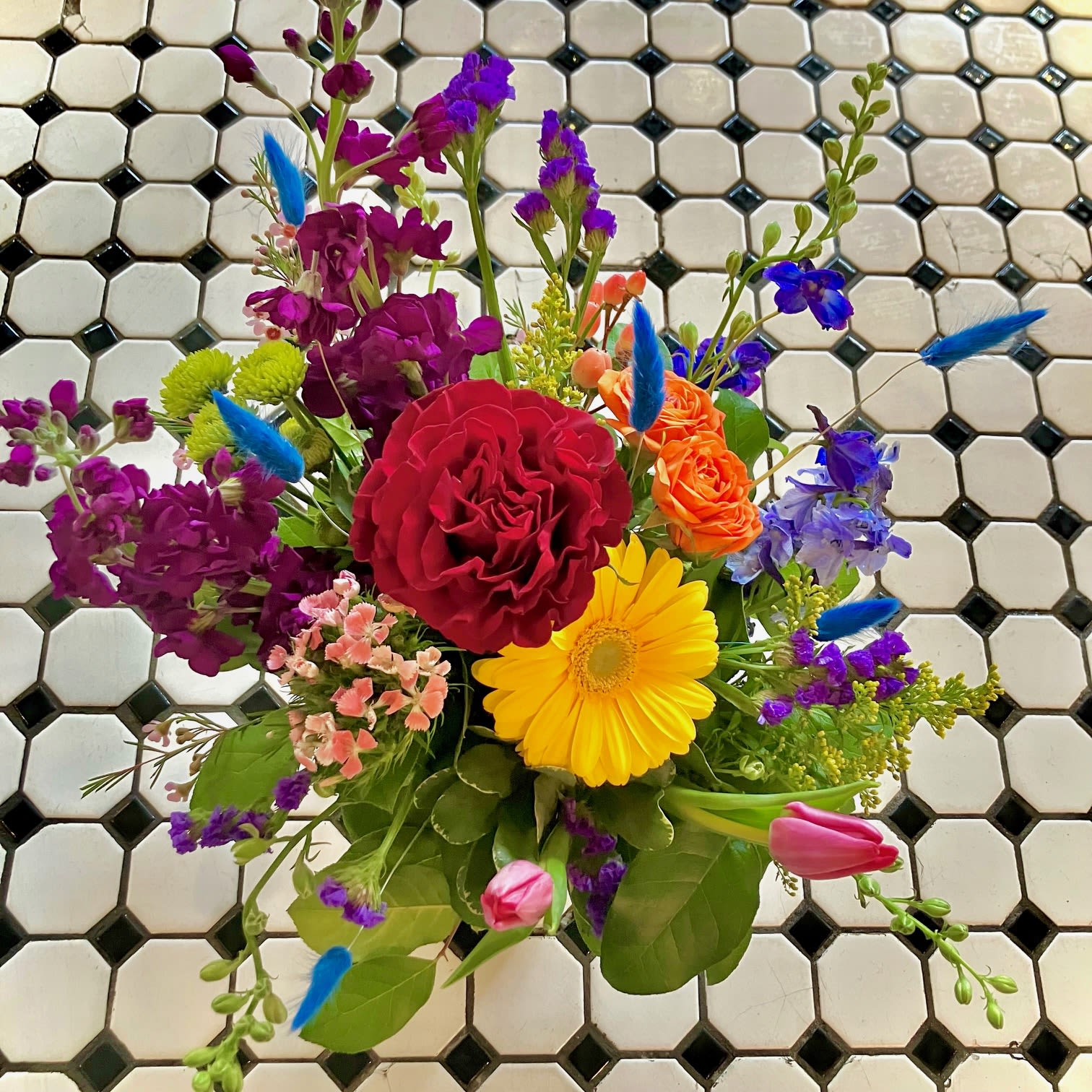 Mixed bouquet with red rose, yellow gerbera, and purple flowers