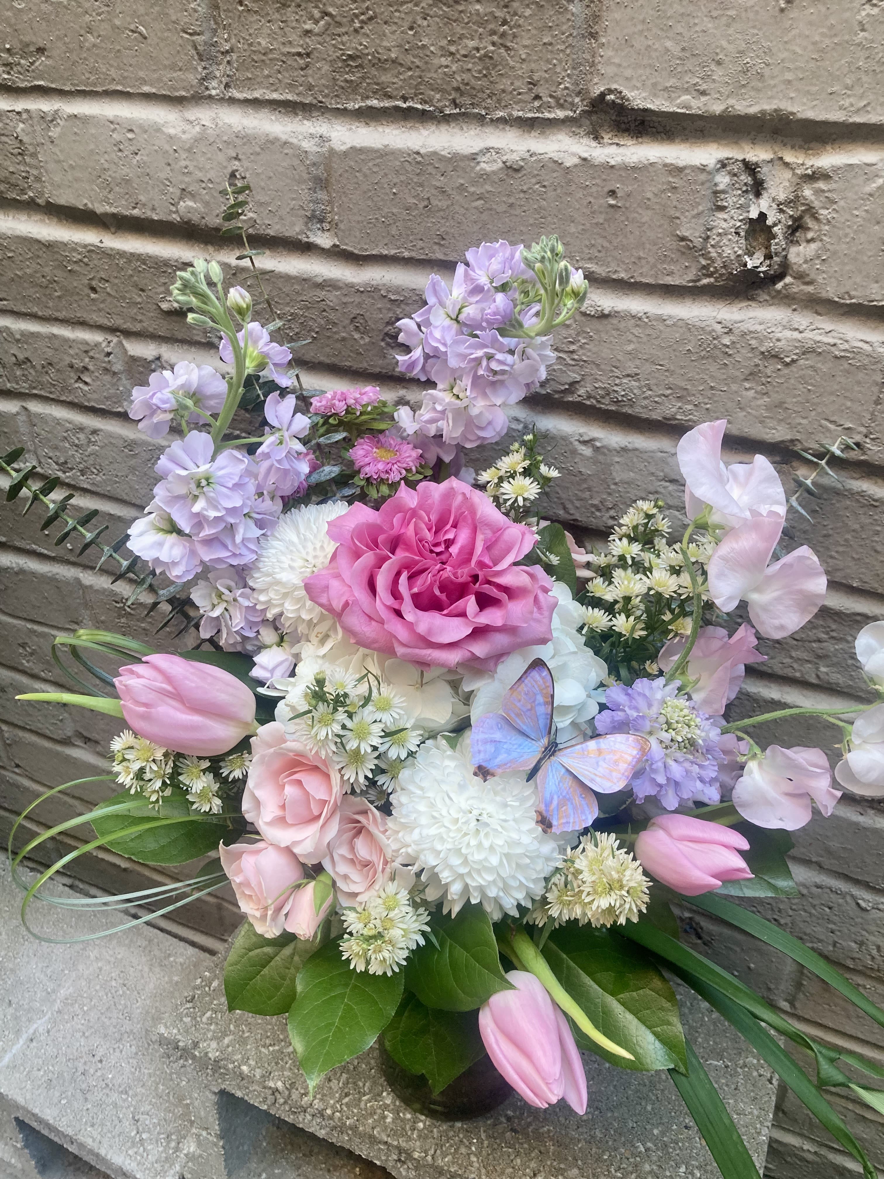 Pink and lavender bouquet with roses, tulips, and a butterfly accent