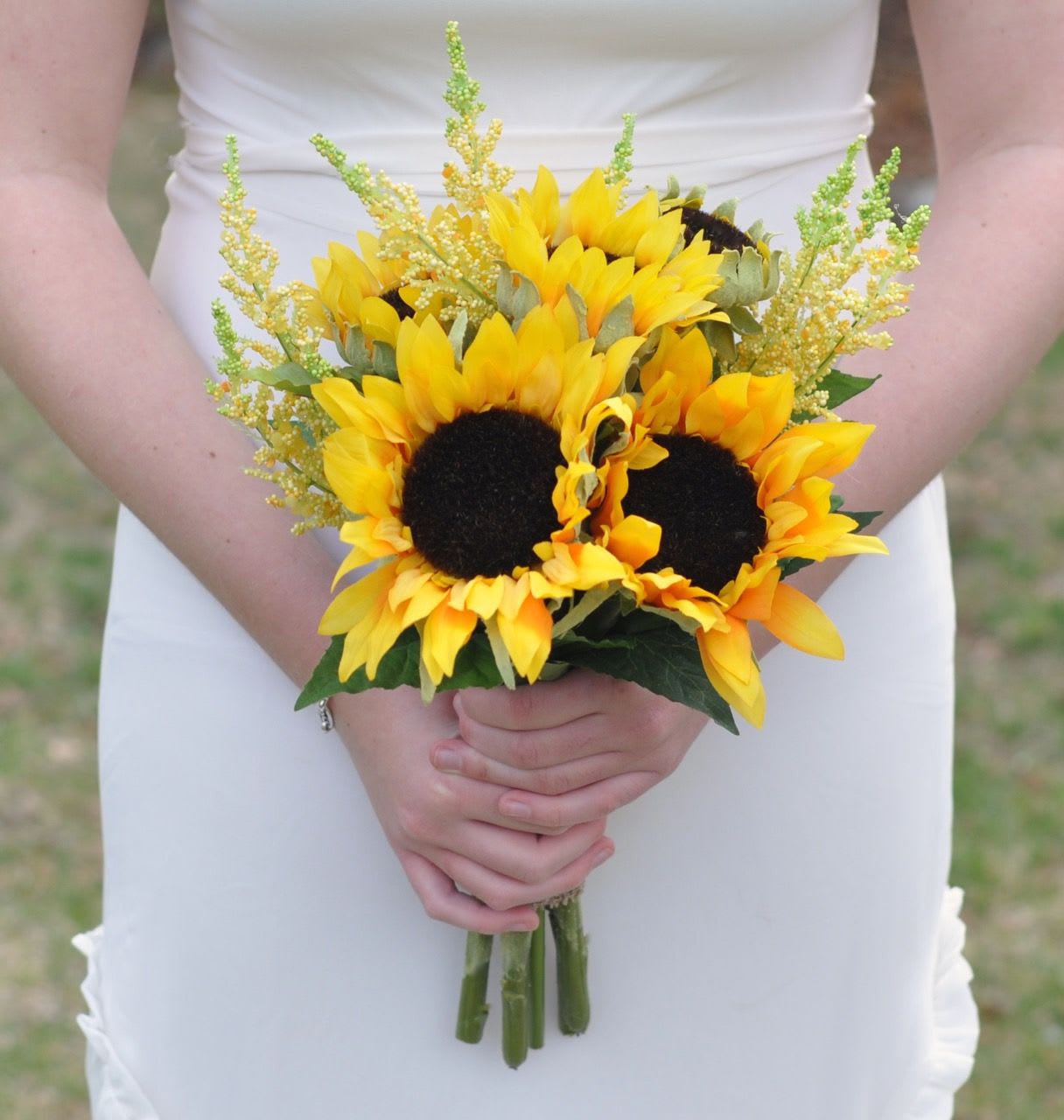 Bride holding a bouquet of yellow sunflowers with airy filler flowers