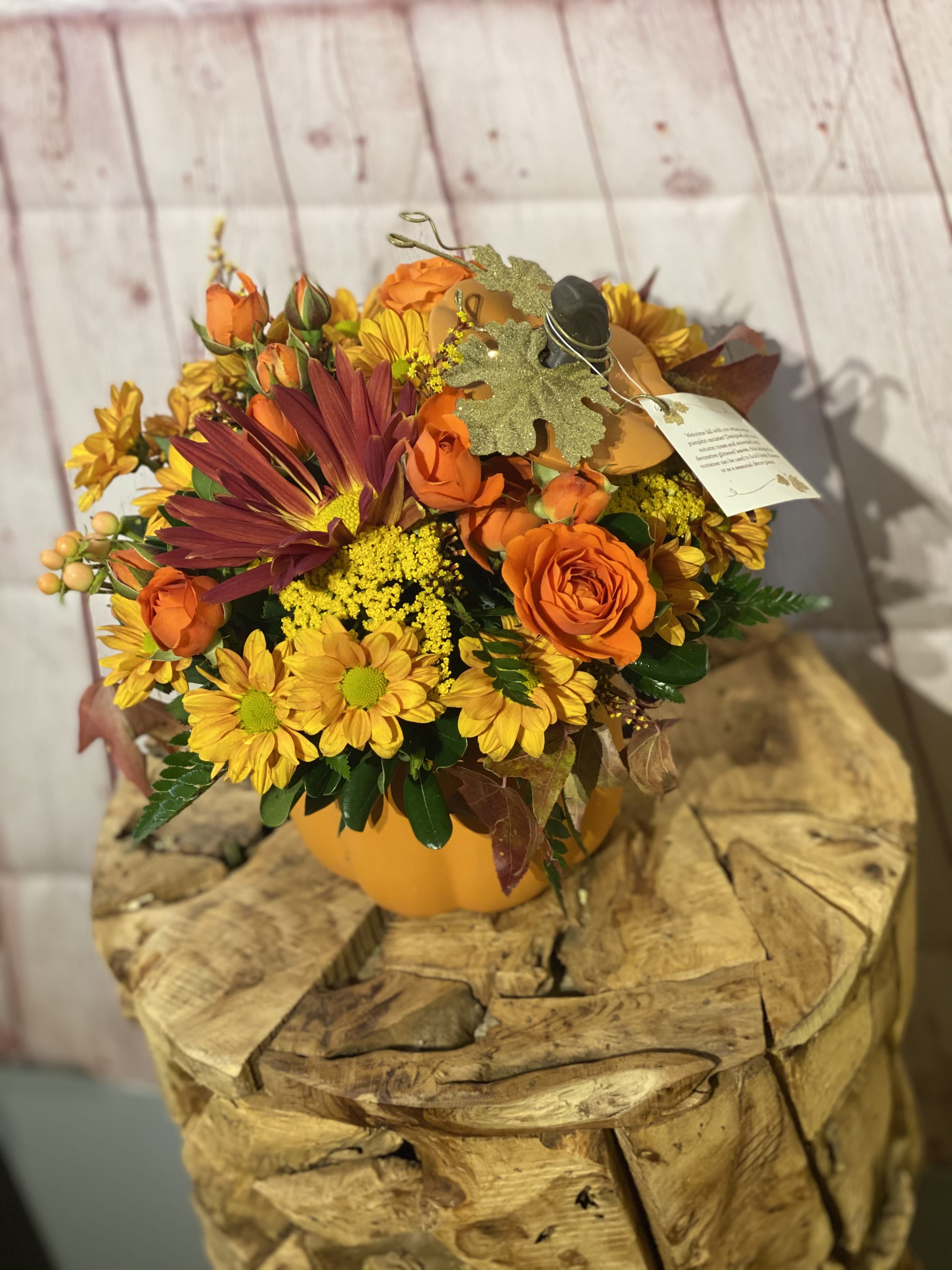 Leo’s Pumpkin Centerpiece - Orange spray roses, yellow daisy, sunflowers and more. Perfect autumn centerpiece or a happy thanksgiving gift.