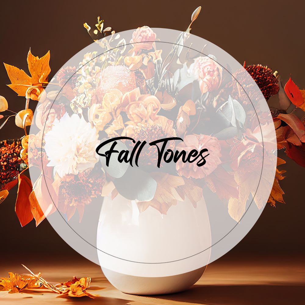 Fall-toned bouquet in a white vase with orange and cream flowers