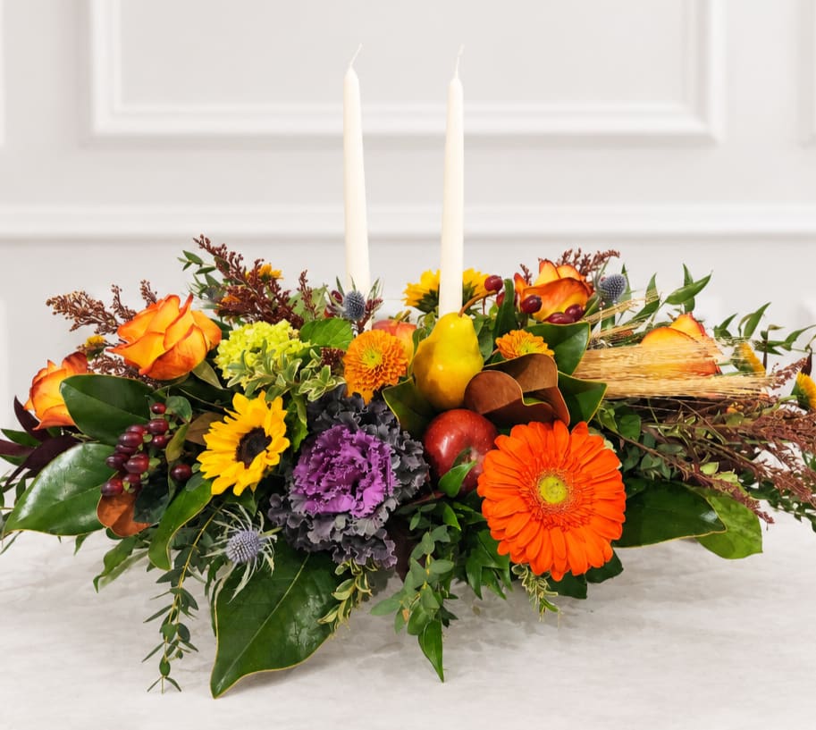 Autumn floral centerpiece with two white taper candles