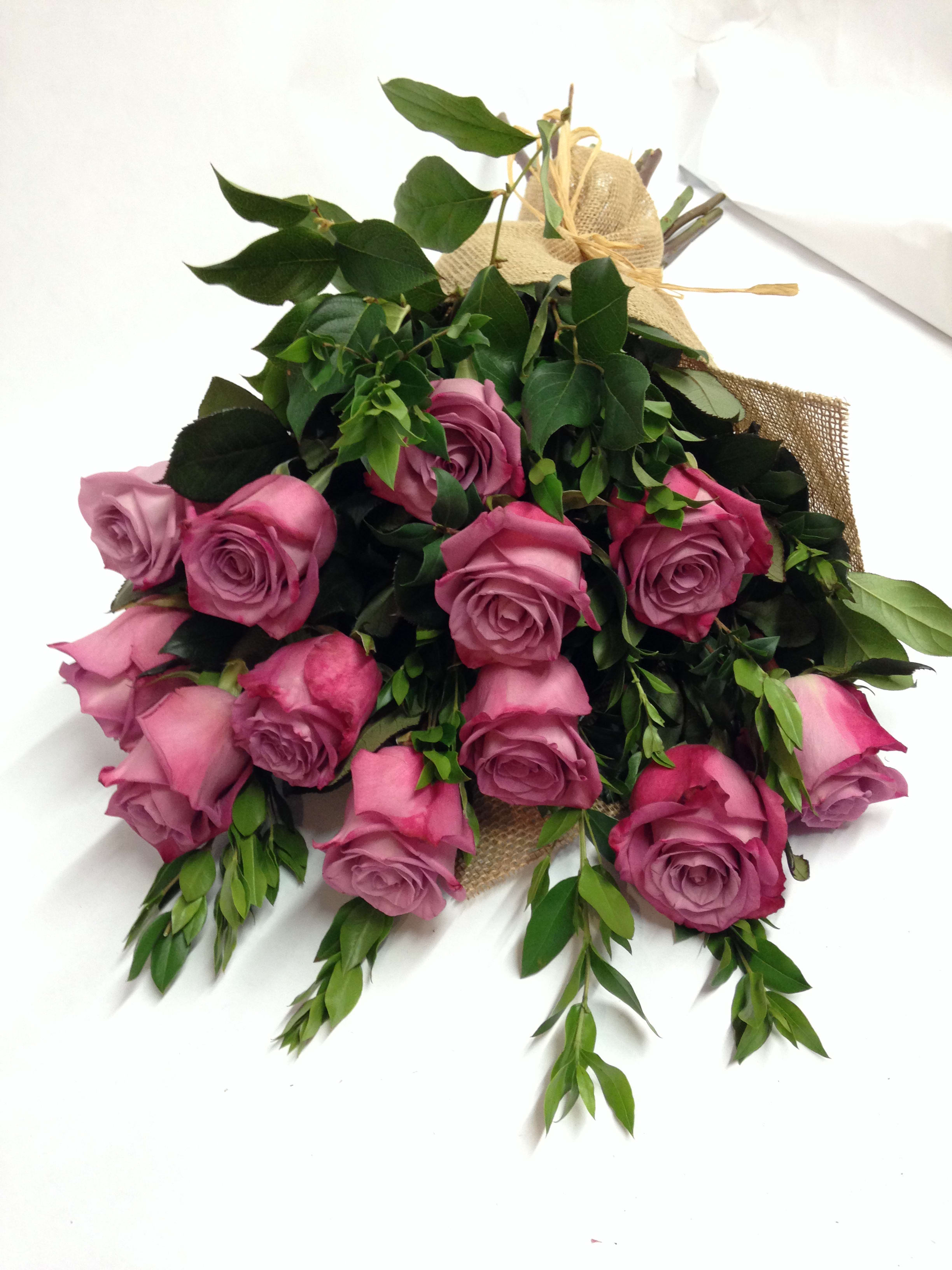 Bouquet of pink roses with greenery wrapped in burlap