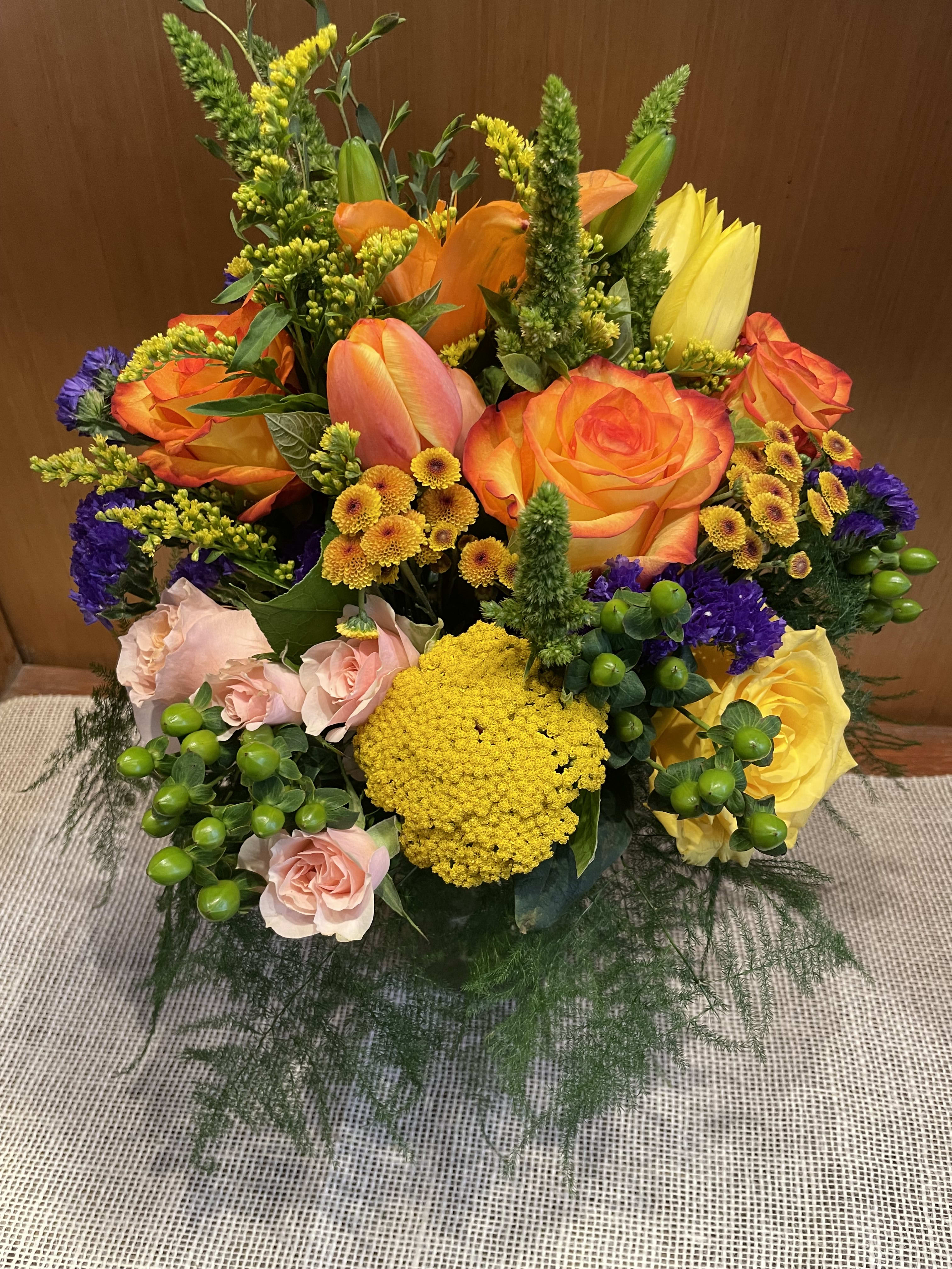 Bright mixed bouquet with orange and yellow roses and pink blooms