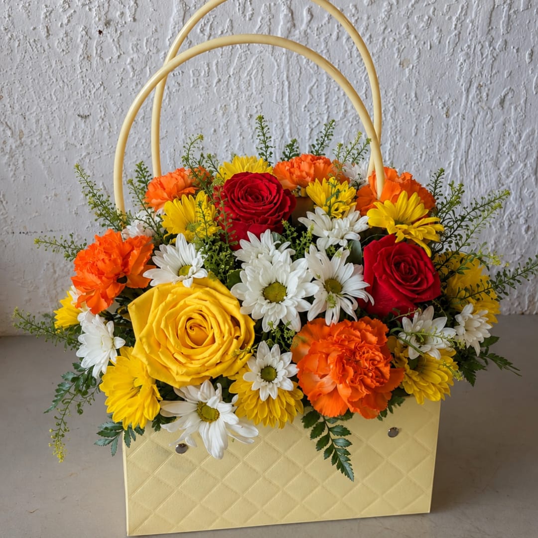 Basket arrangement of red and yellow roses with white daisies and orange carnations