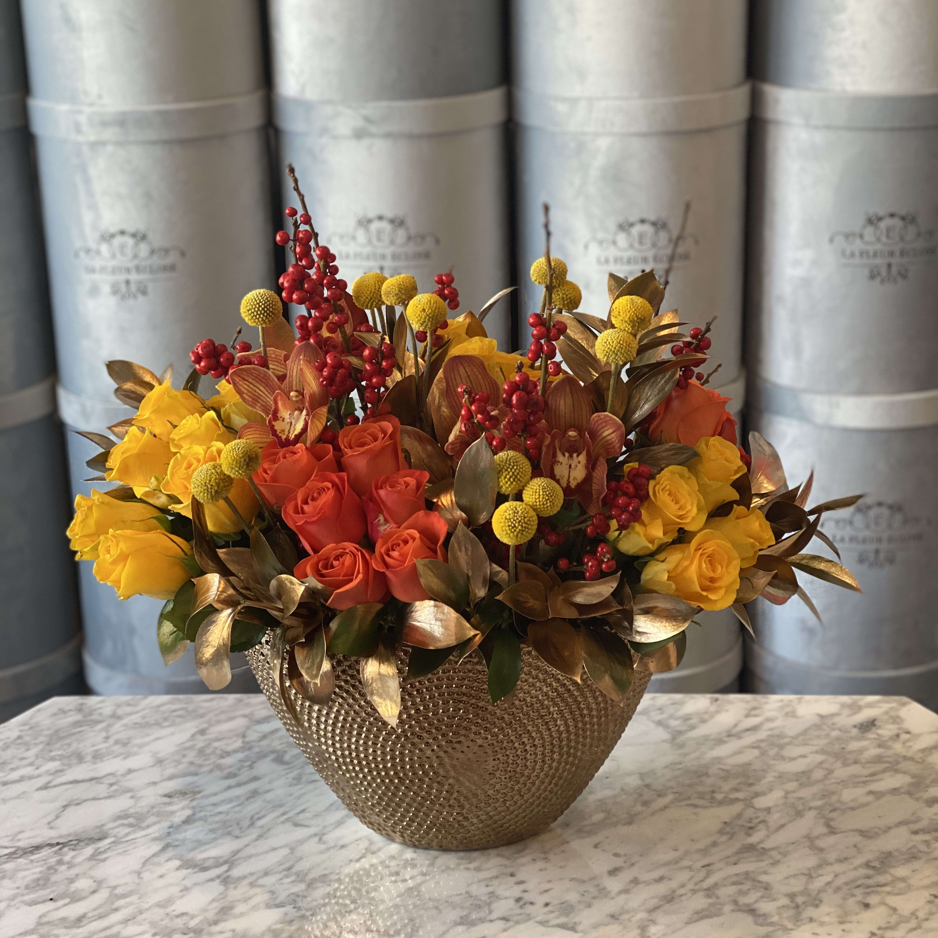 Golden Autumn  - Beautiful gold vase filled with yellow and orange roses and some decorative greenery and golden leaves. 