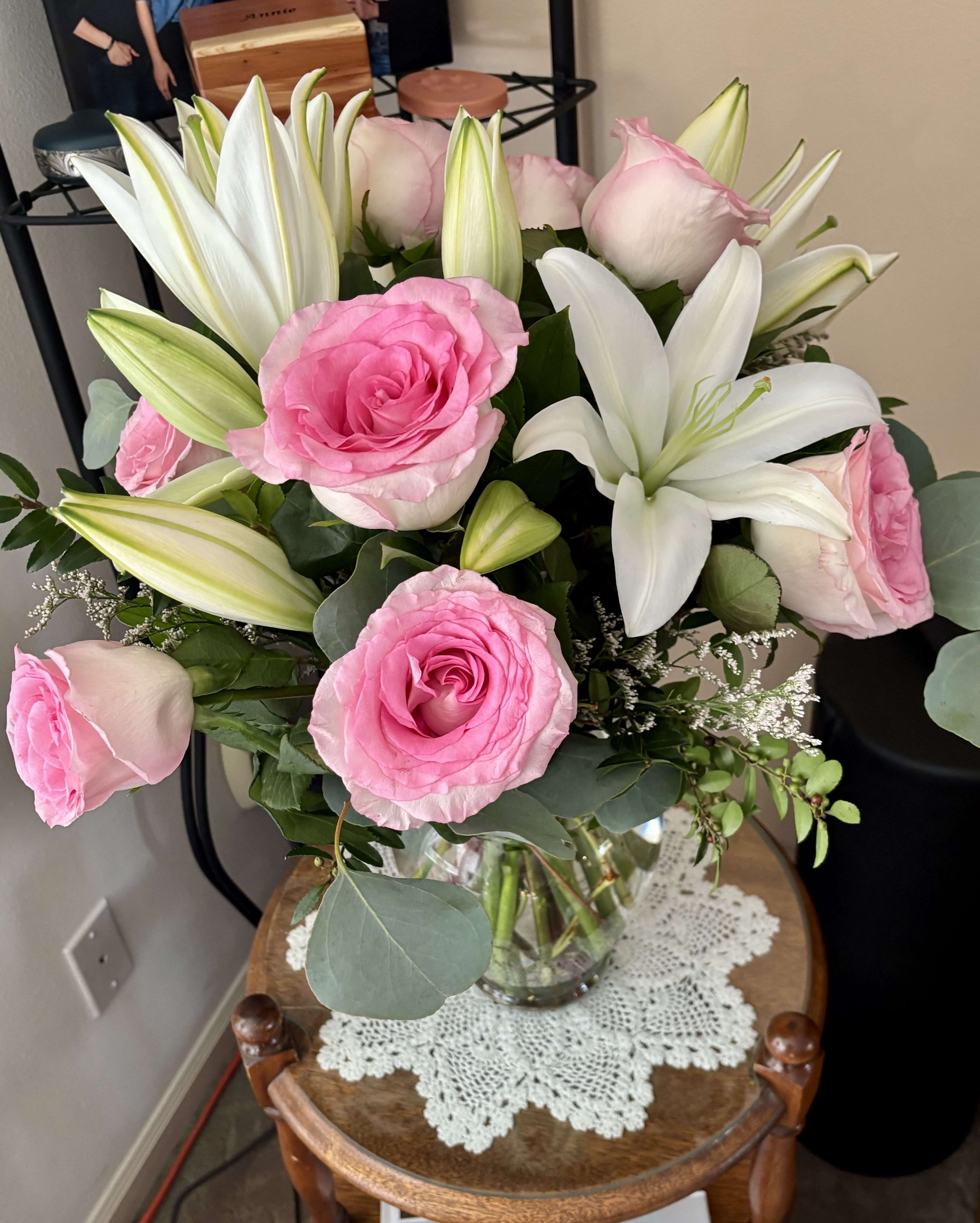 Pink roses and white lilies arranged in a clear glass vase