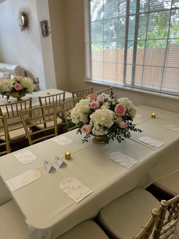 Pink and white floral centerpieces on a decorated banquet table