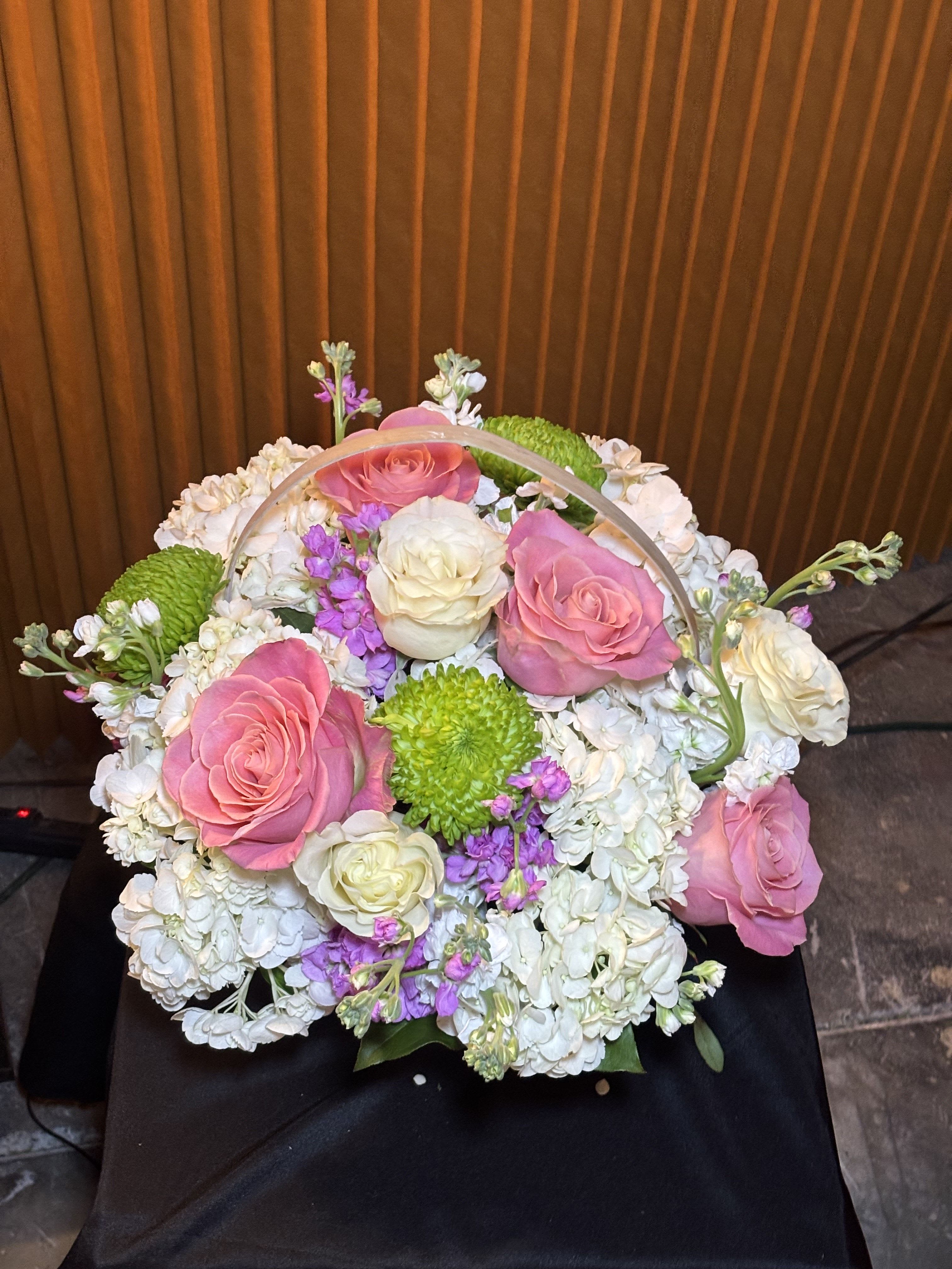Basket arrangement of pink and white roses with white hydrangeas and green mums