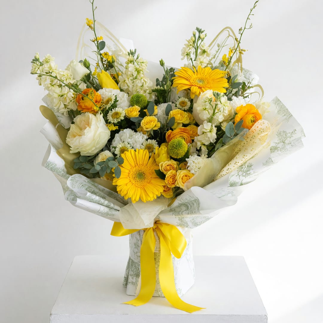 Yellow and white mixed bouquet wrapped with a yellow ribbon