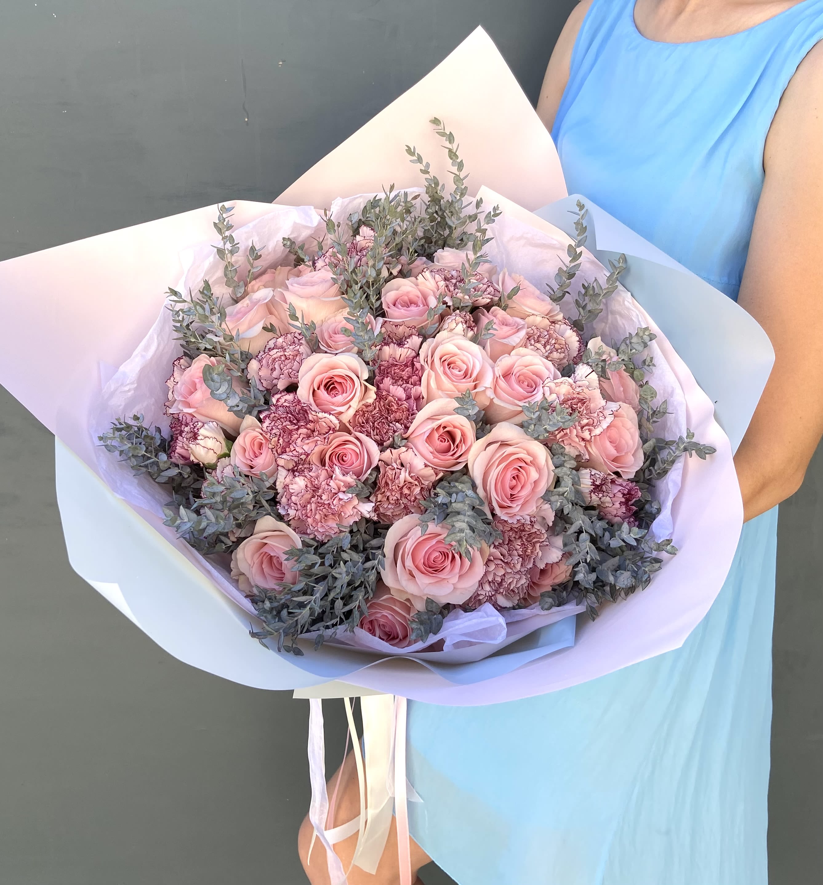 Roses &amp; Carnations in Bouquet D - DELUXE size is shown in the main pic. Same-Day Delivery is usually available in white, red, peach, and pink. Other colors are available for Next-Day Delivery. The colors are up to the florist, but you can specify your preferred colors in the Notes or call us. This elegant bouquet features soft blush roses paired with ruffled carnations, highlighted by delicate greenery. The blend of pastel hues and intricate textures creates a timeless and romantic arrangement, perfect for weddings, anniversaries, or any occasion that calls for a touch of grace and beauty. 