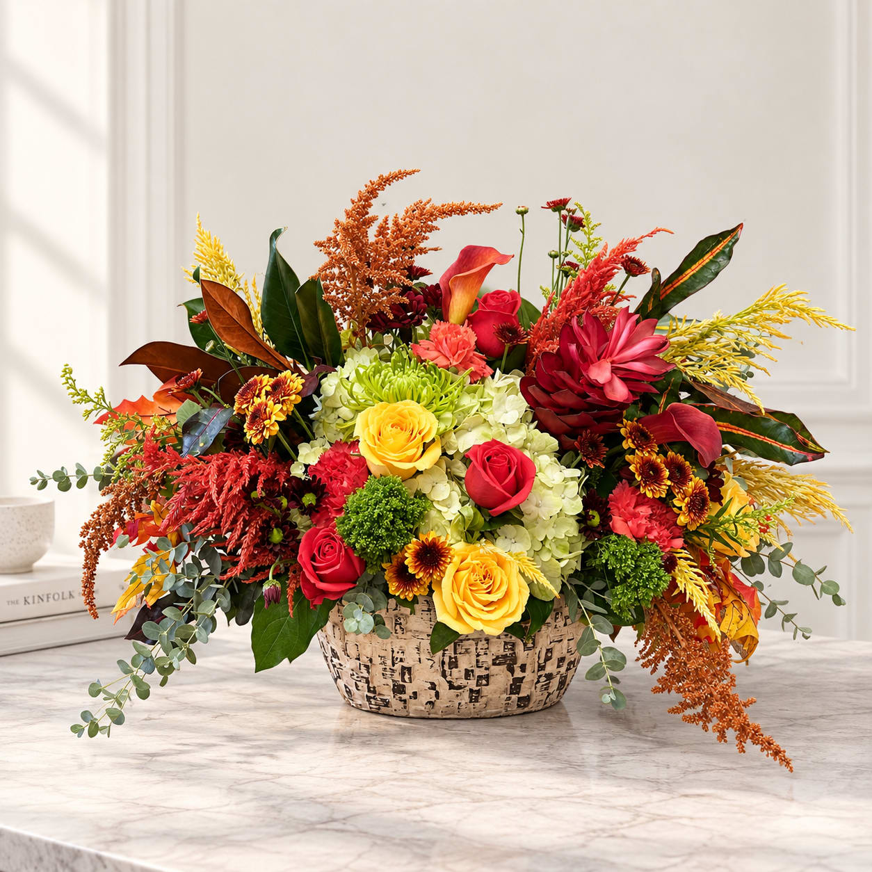 Colorful mixed flower arrangement in a patterned basket on a table
