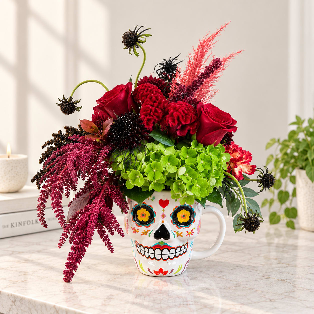 Red roses and bright green hydrangeas in a decorated skull mug