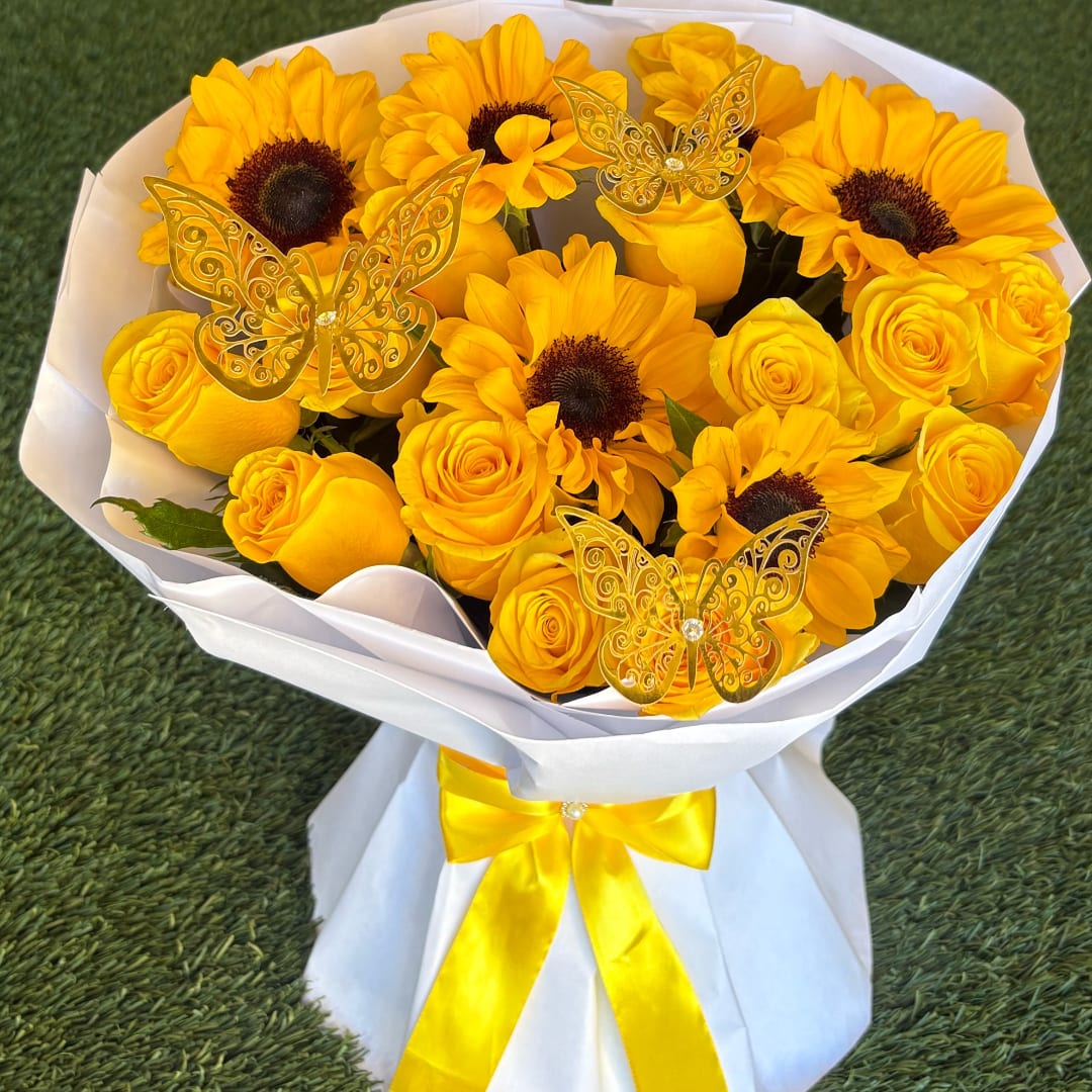 Yellow roses and sunflowers in white wrapping with butterfly picks