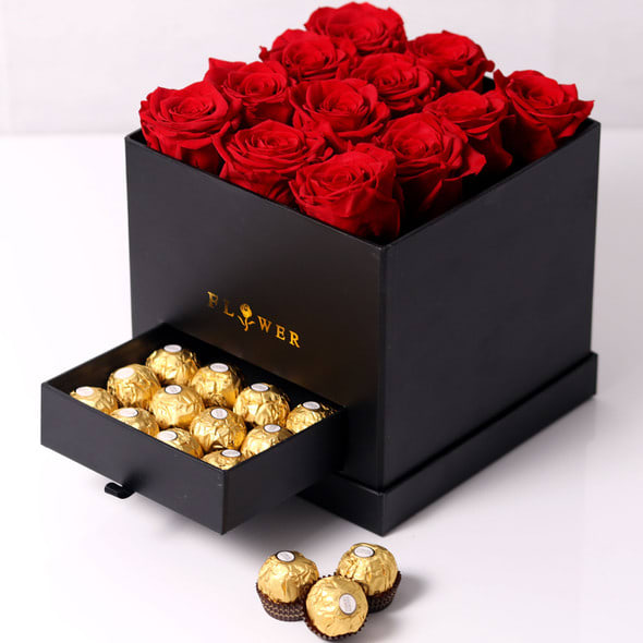 Red roses in a black box with a drawer of gold-wrapped chocolates