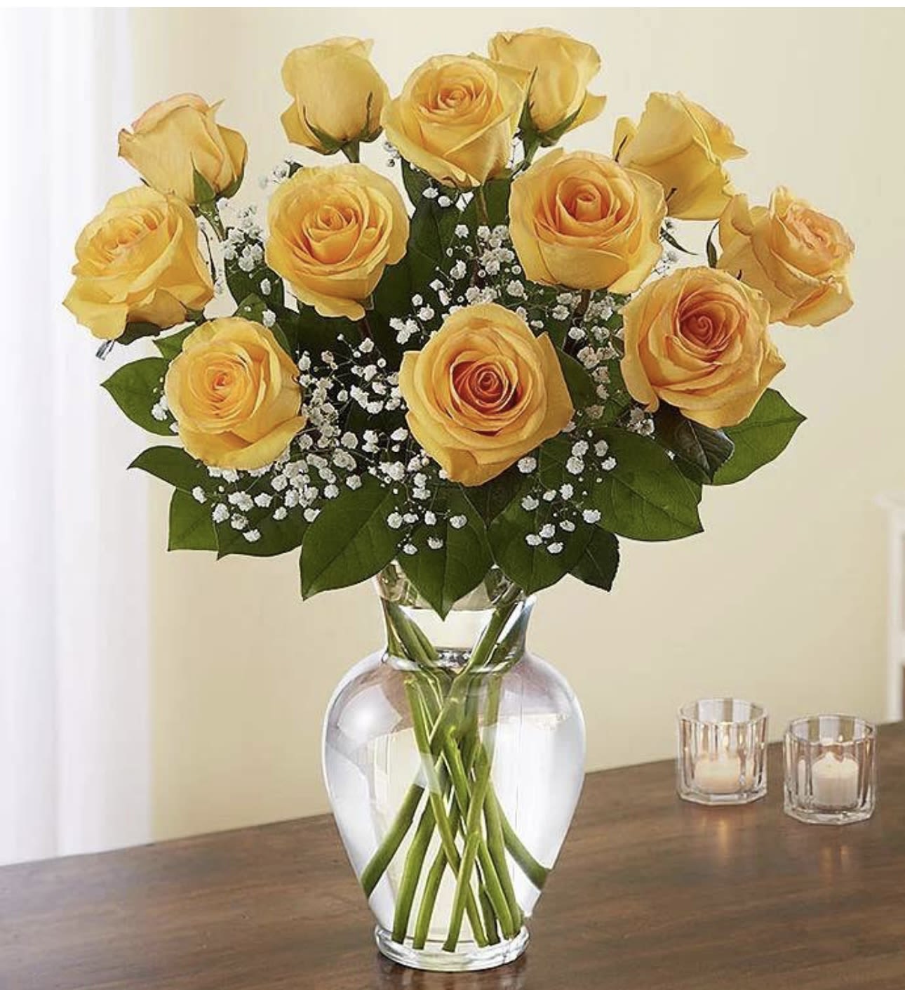Yellow roses arranged in a clear glass vase with baby's breath