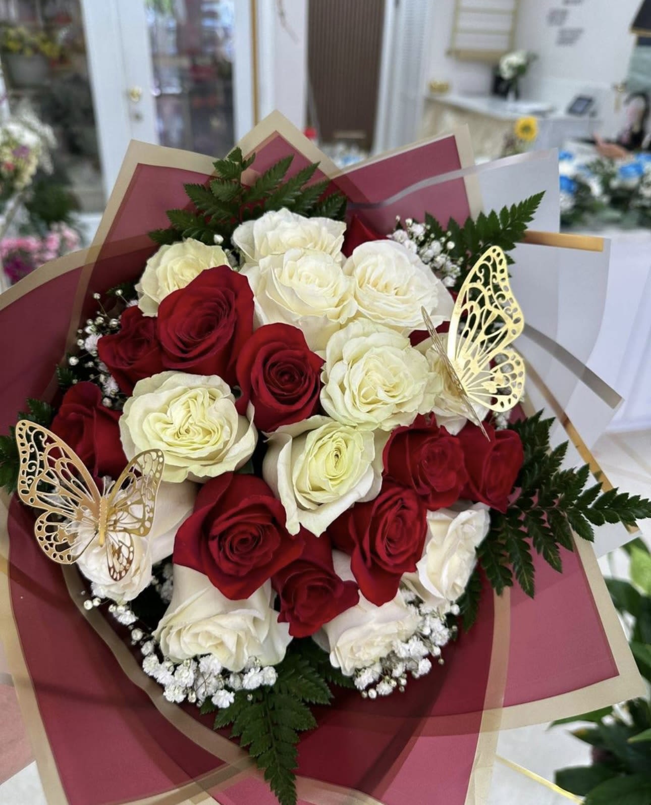 Bouquet of red and white roses with butterfly decorations