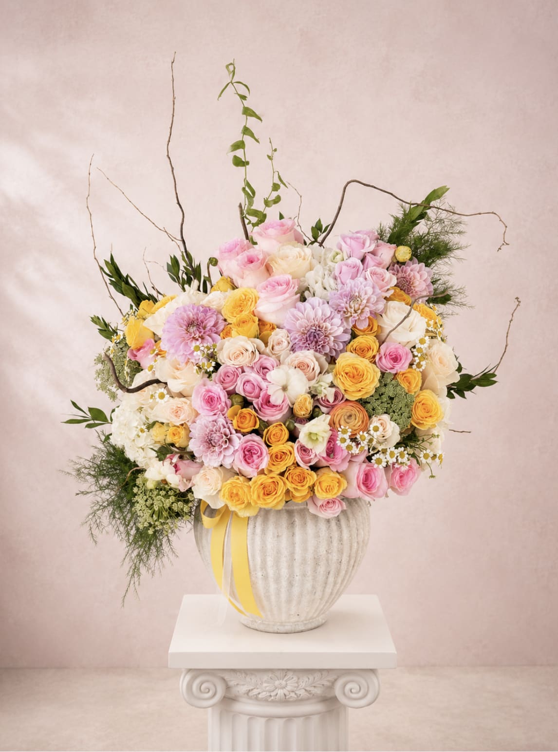 Large pastel bouquet of roses and dahlias in a ribbed vase