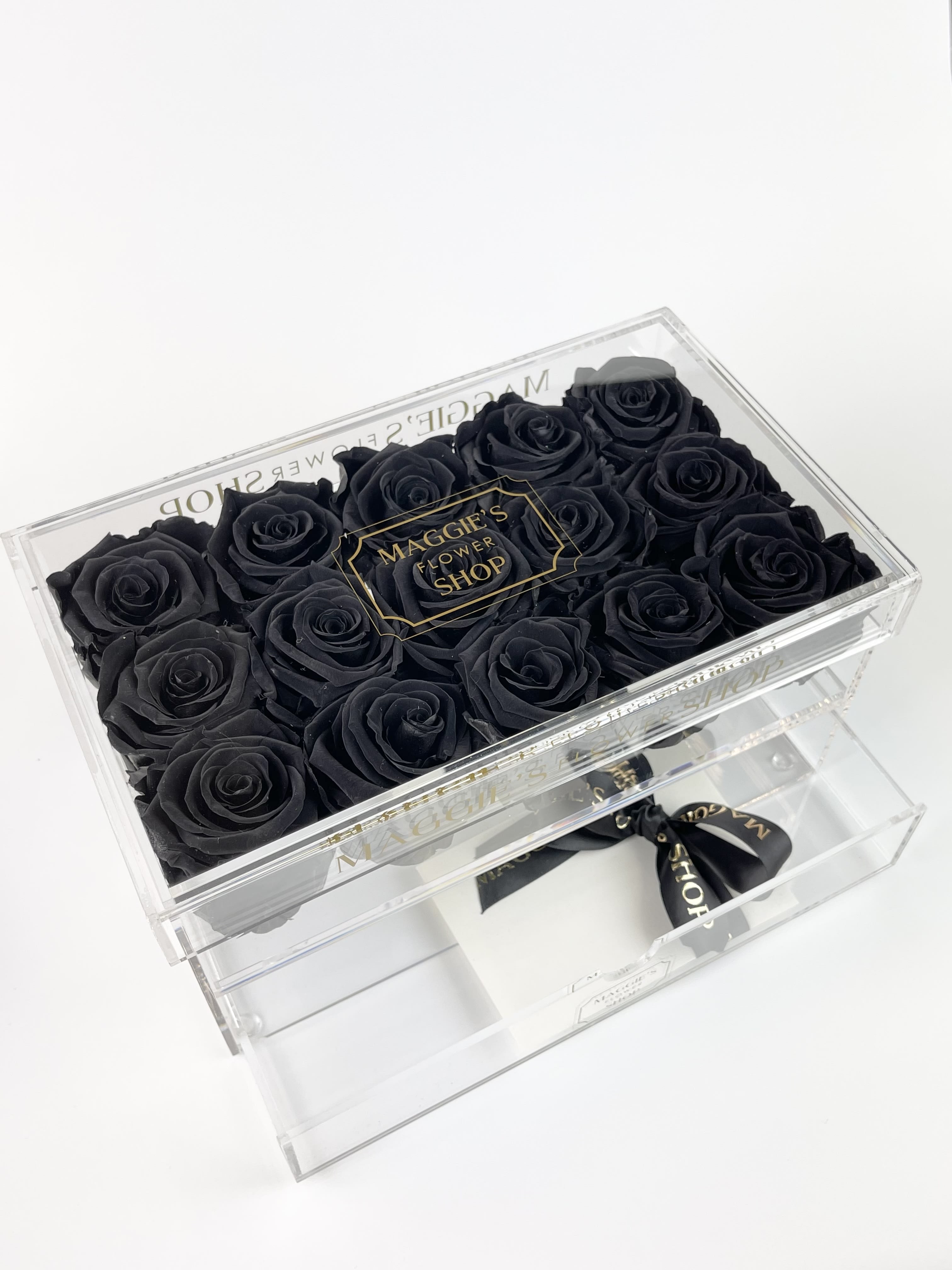 Black roses in a clear acrylic gift box with a drawer and ribbon