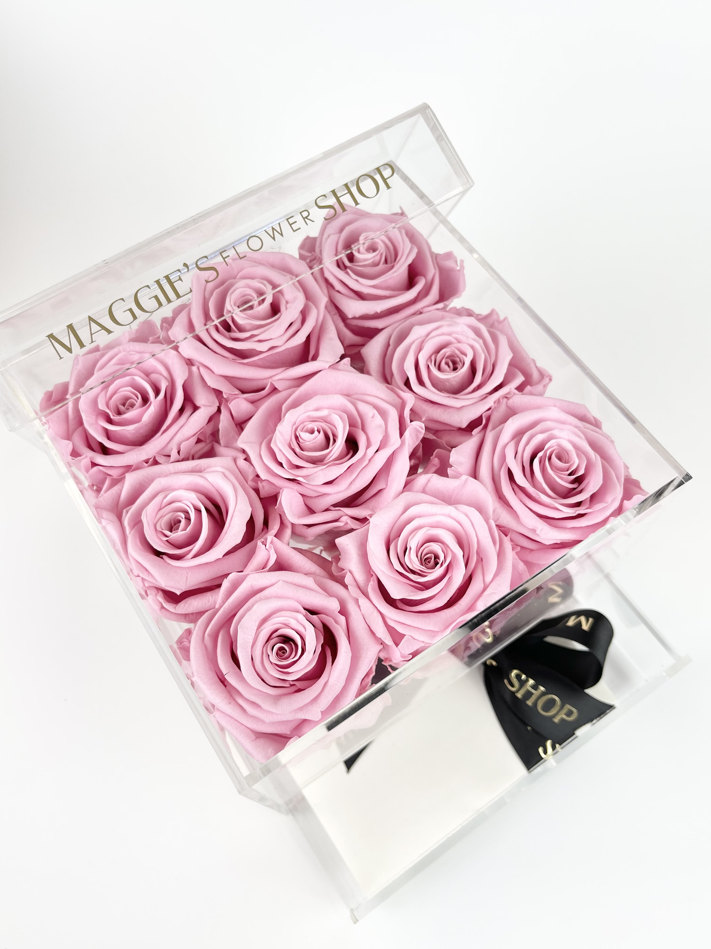Box of pink roses in a clear gift box with a ribbon