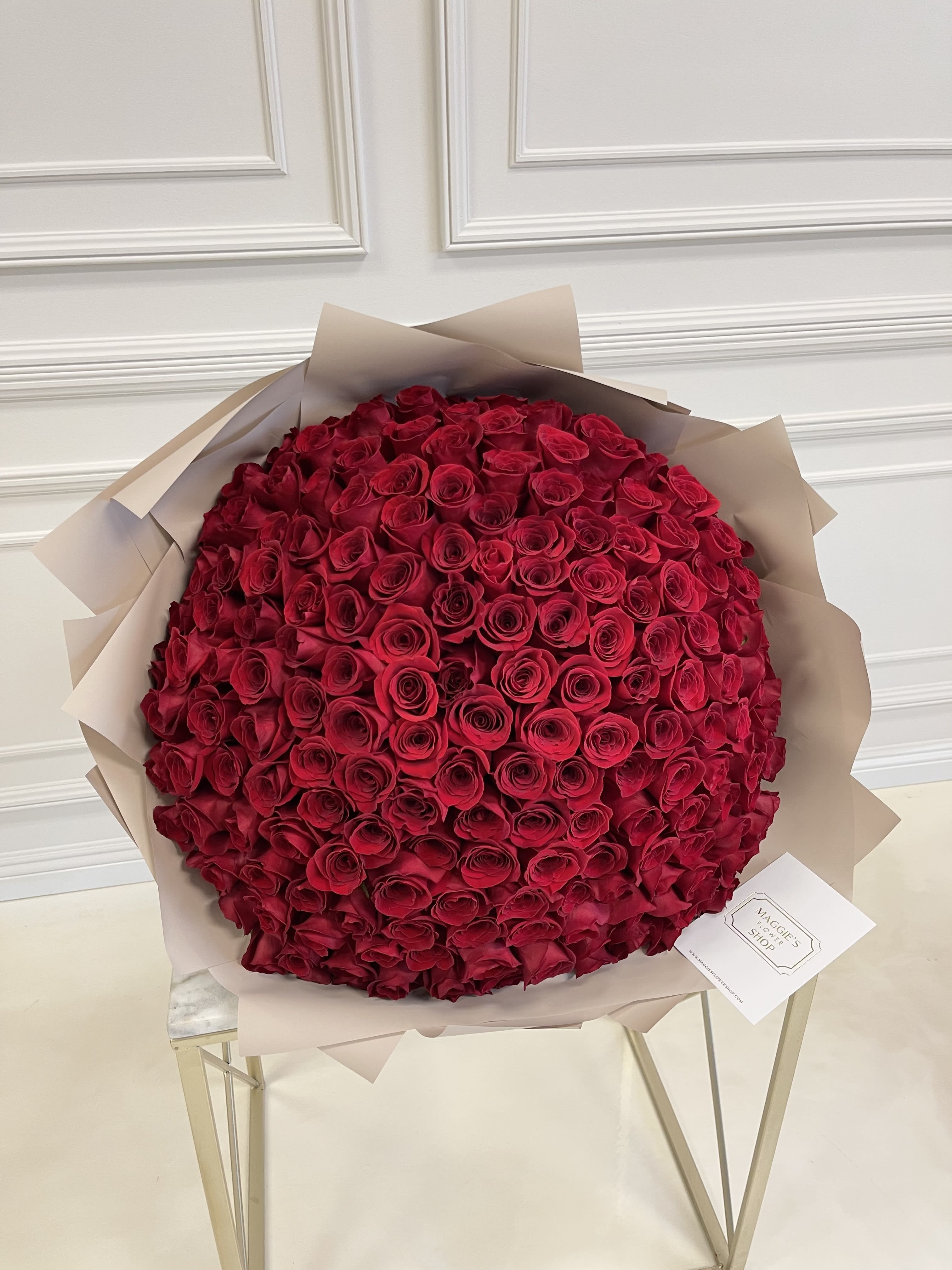 Large bouquet of red roses wrapped in beige paper