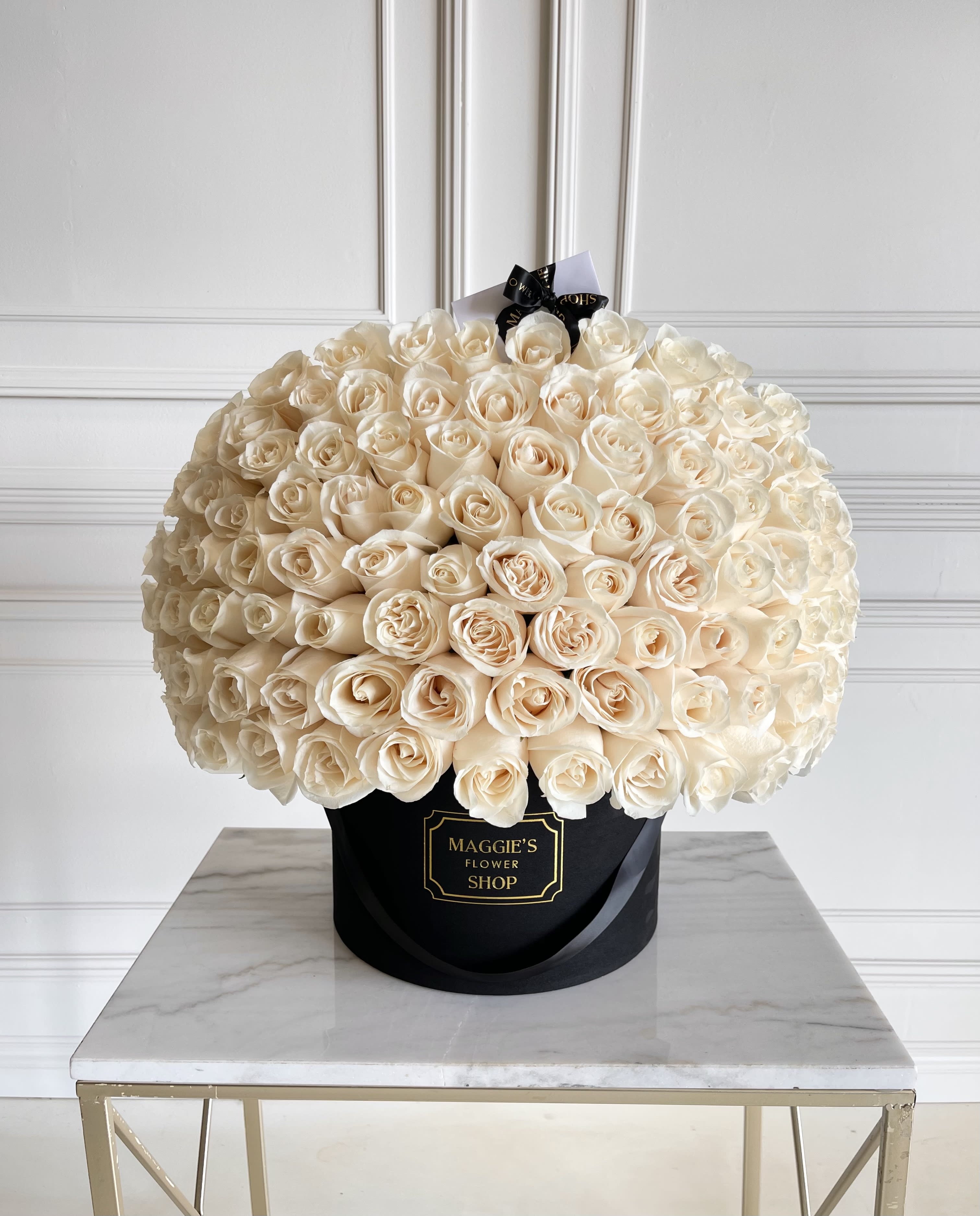 Large bouquet of cream roses in a black hatbox
