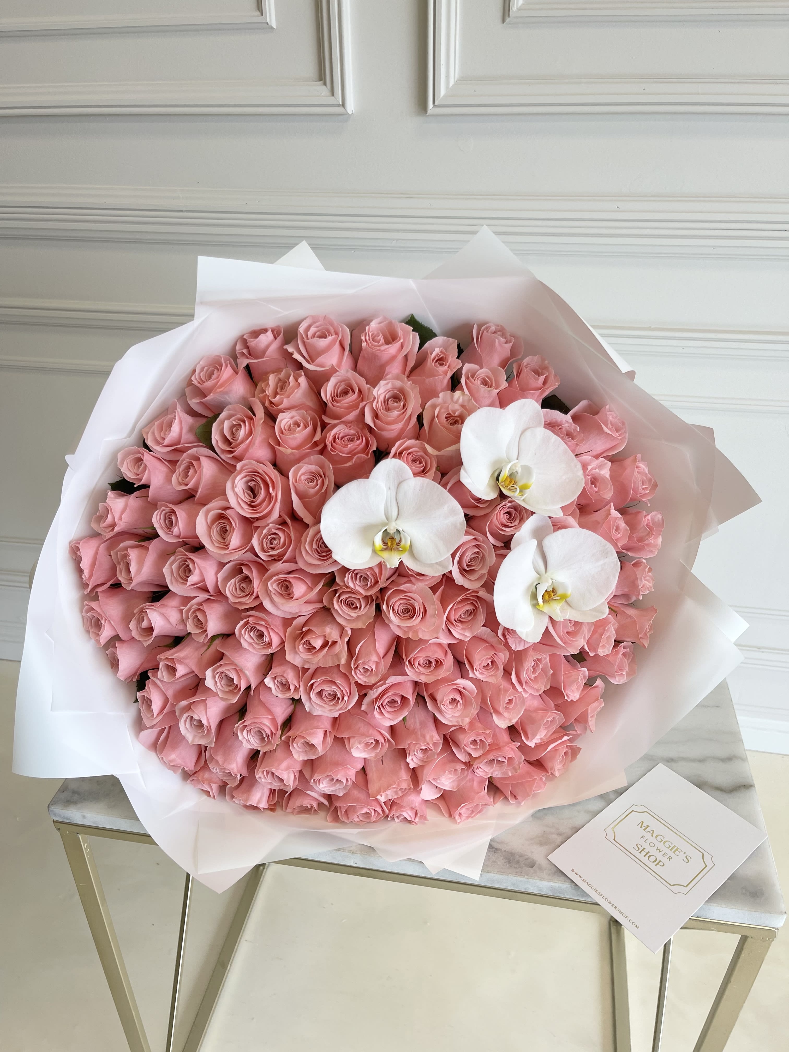 Large bouquet of pink roses with three white orchids