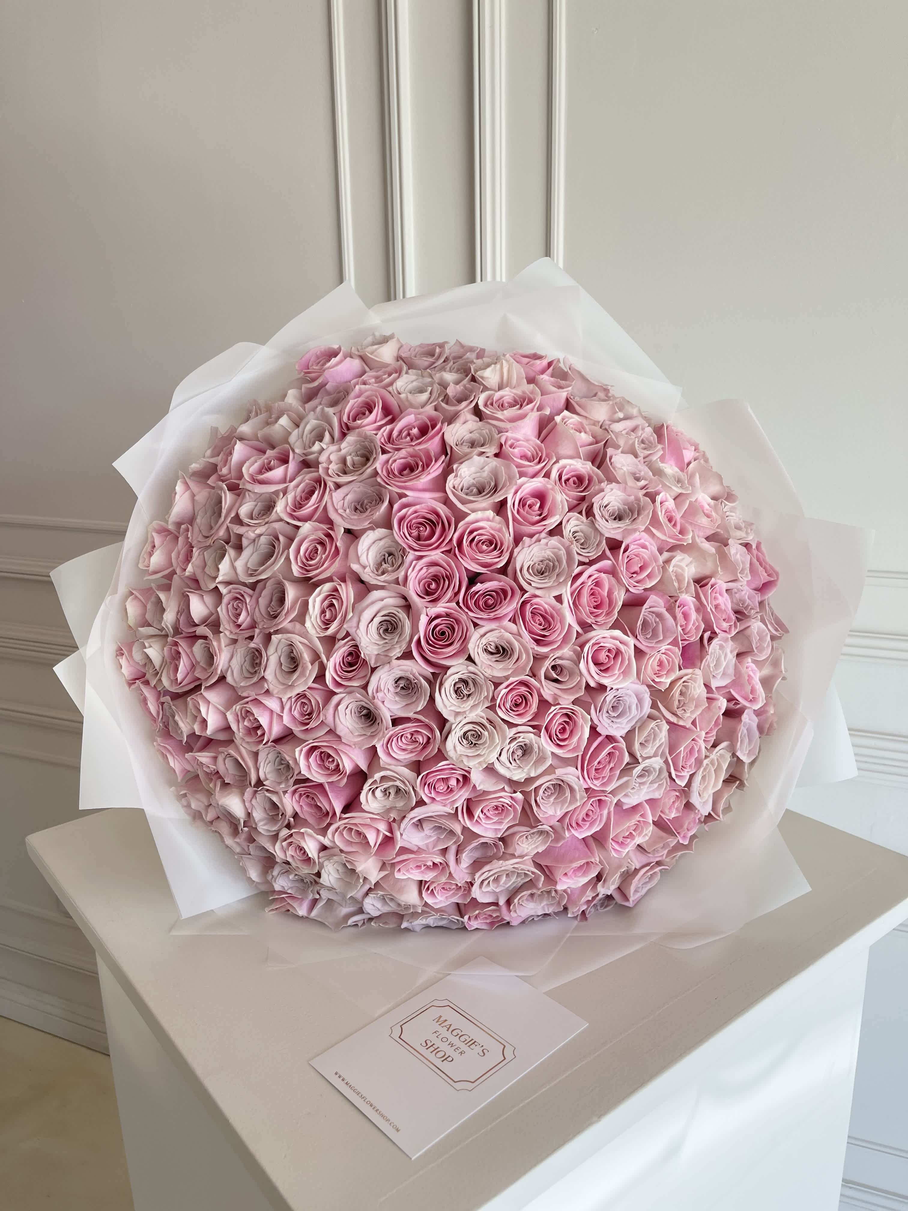 Large bouquet of pink roses wrapped in white paper