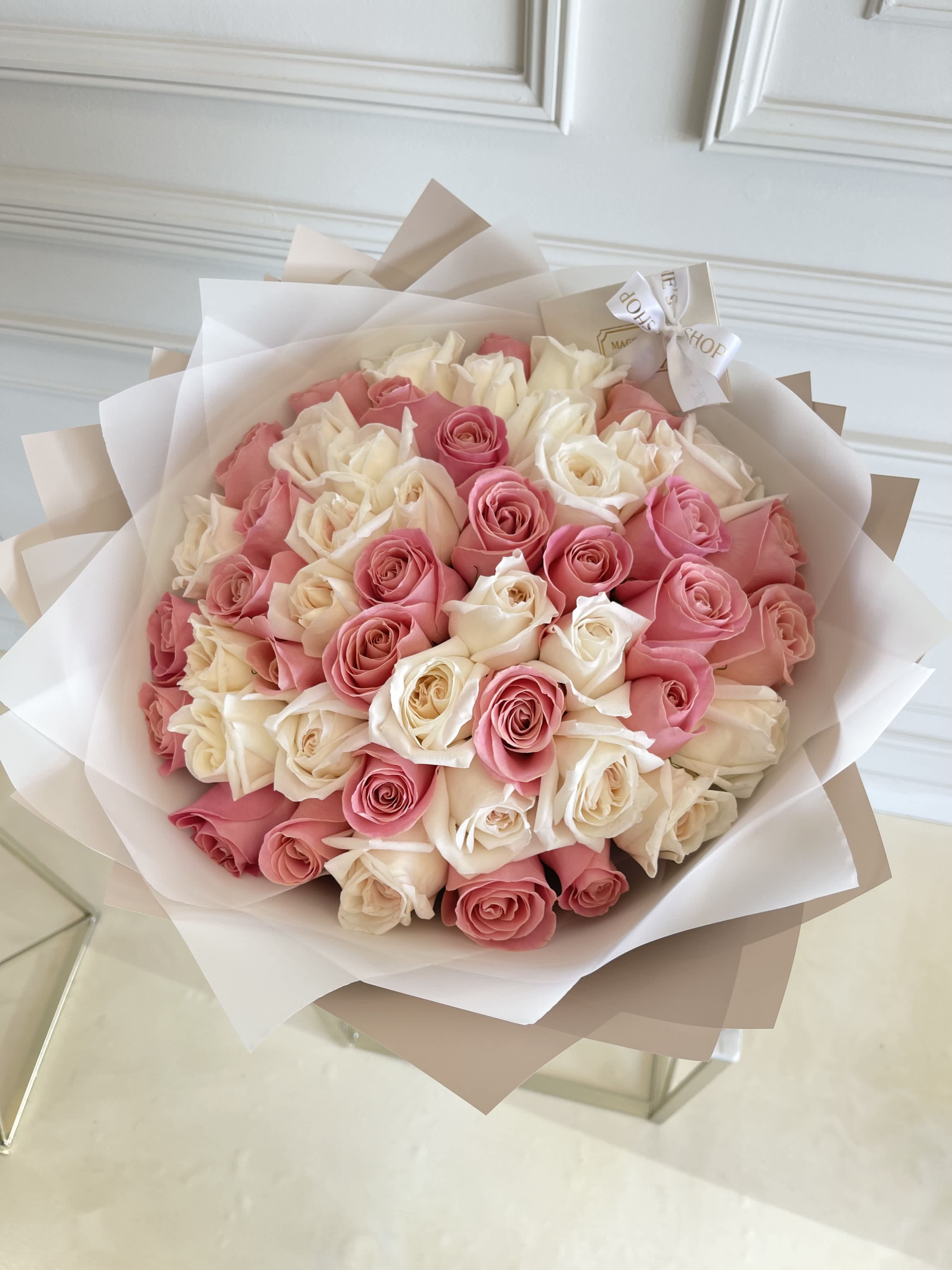 Bouquet of pink and white roses wrapped in layered paper