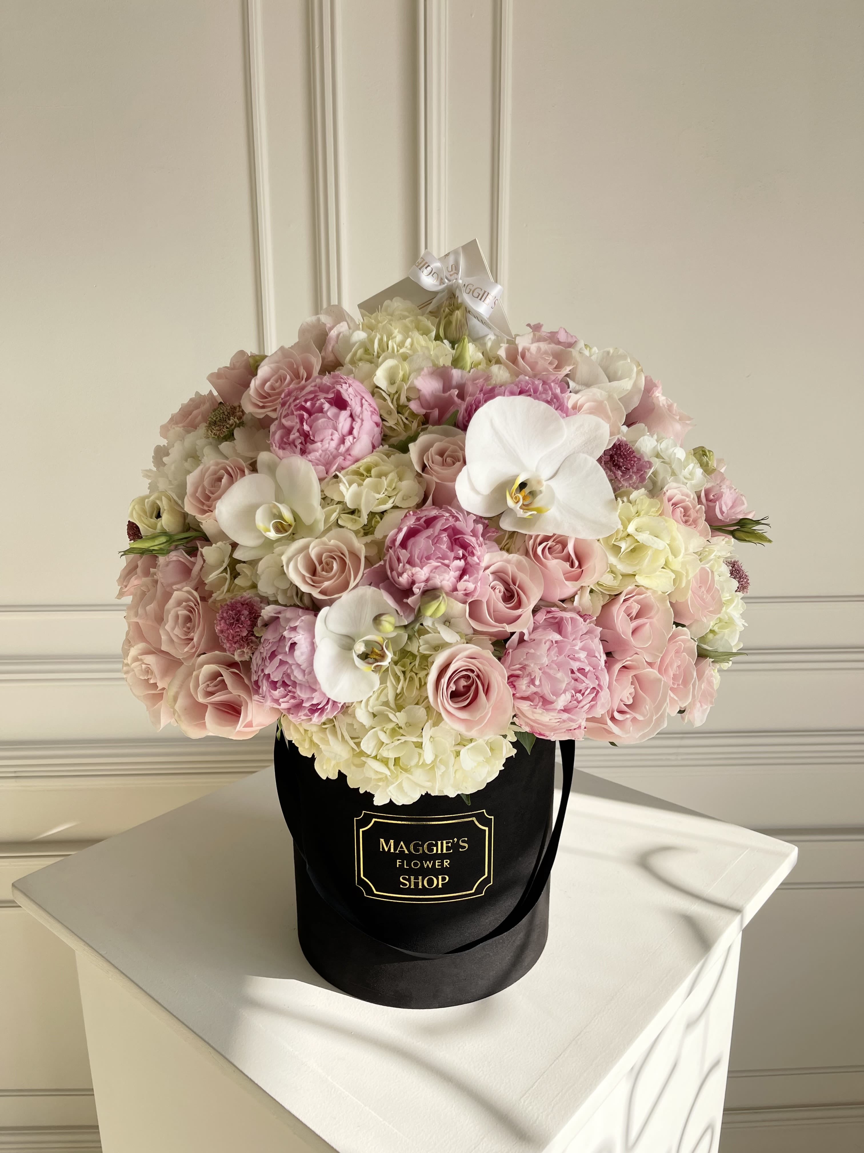 Pink and white bouquet in a black hat box