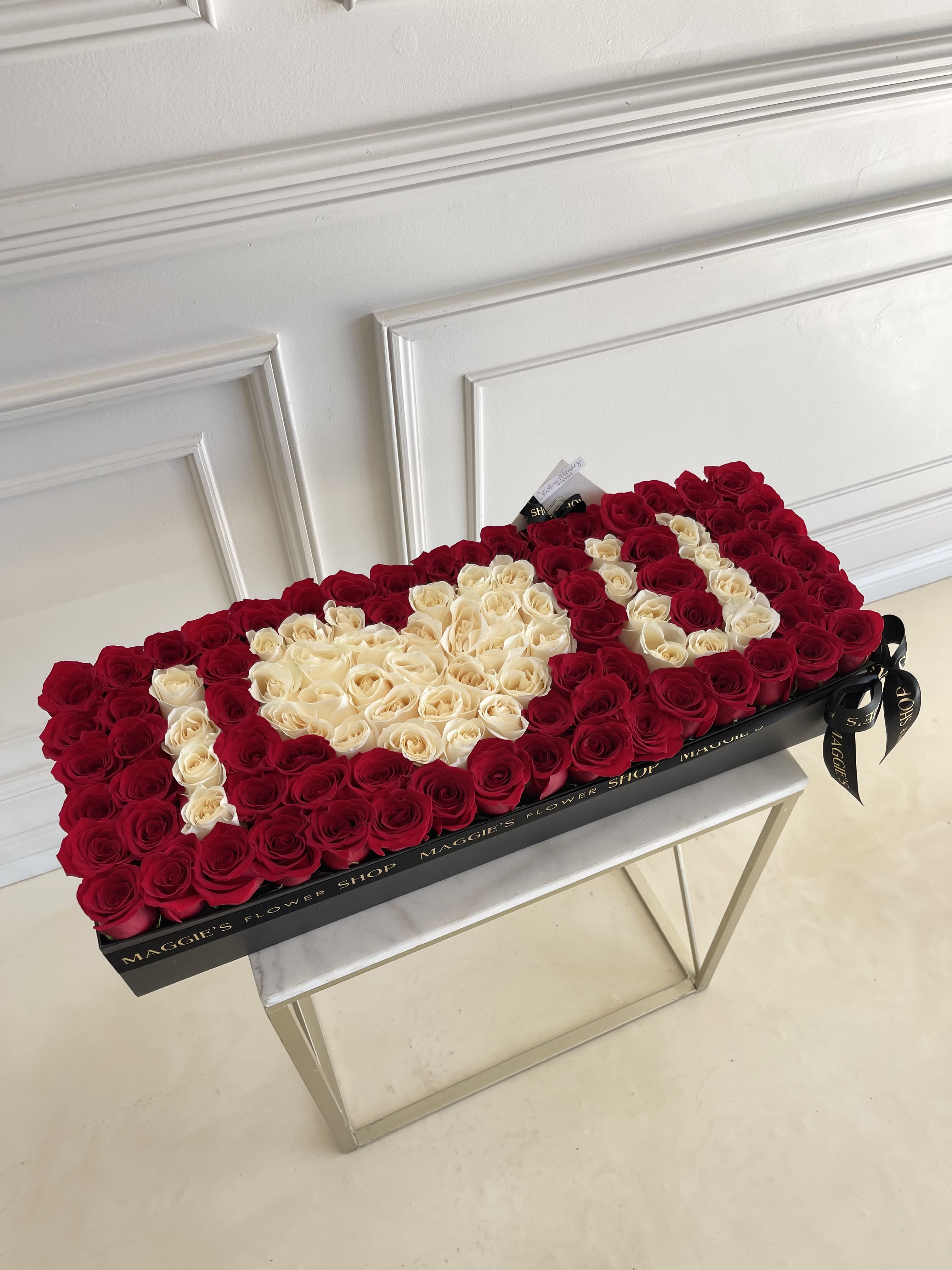 Heart-shaped box of red and cream roses on a table