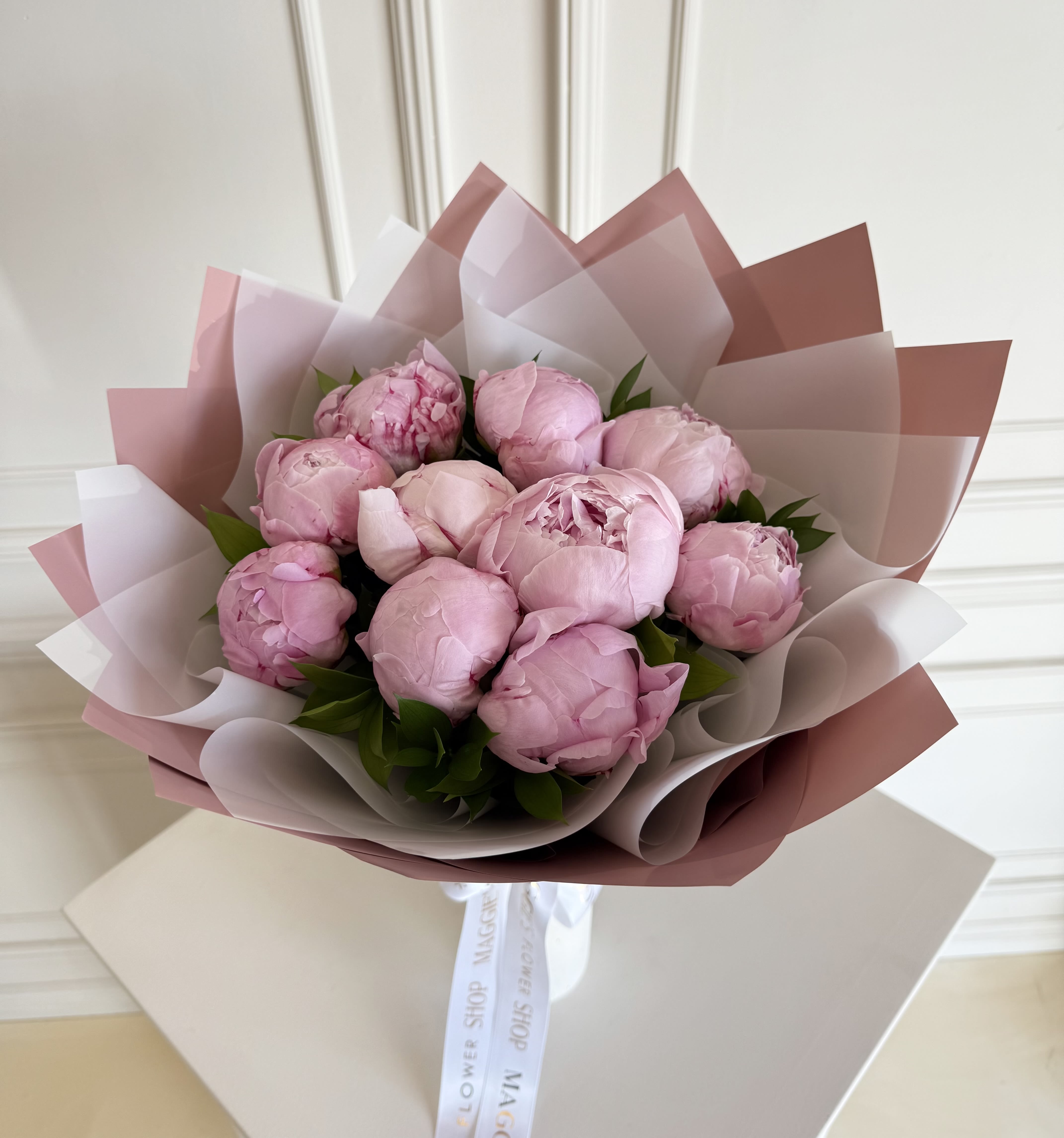 Bouquet of pink peonies wrapped in layered pink and white paper