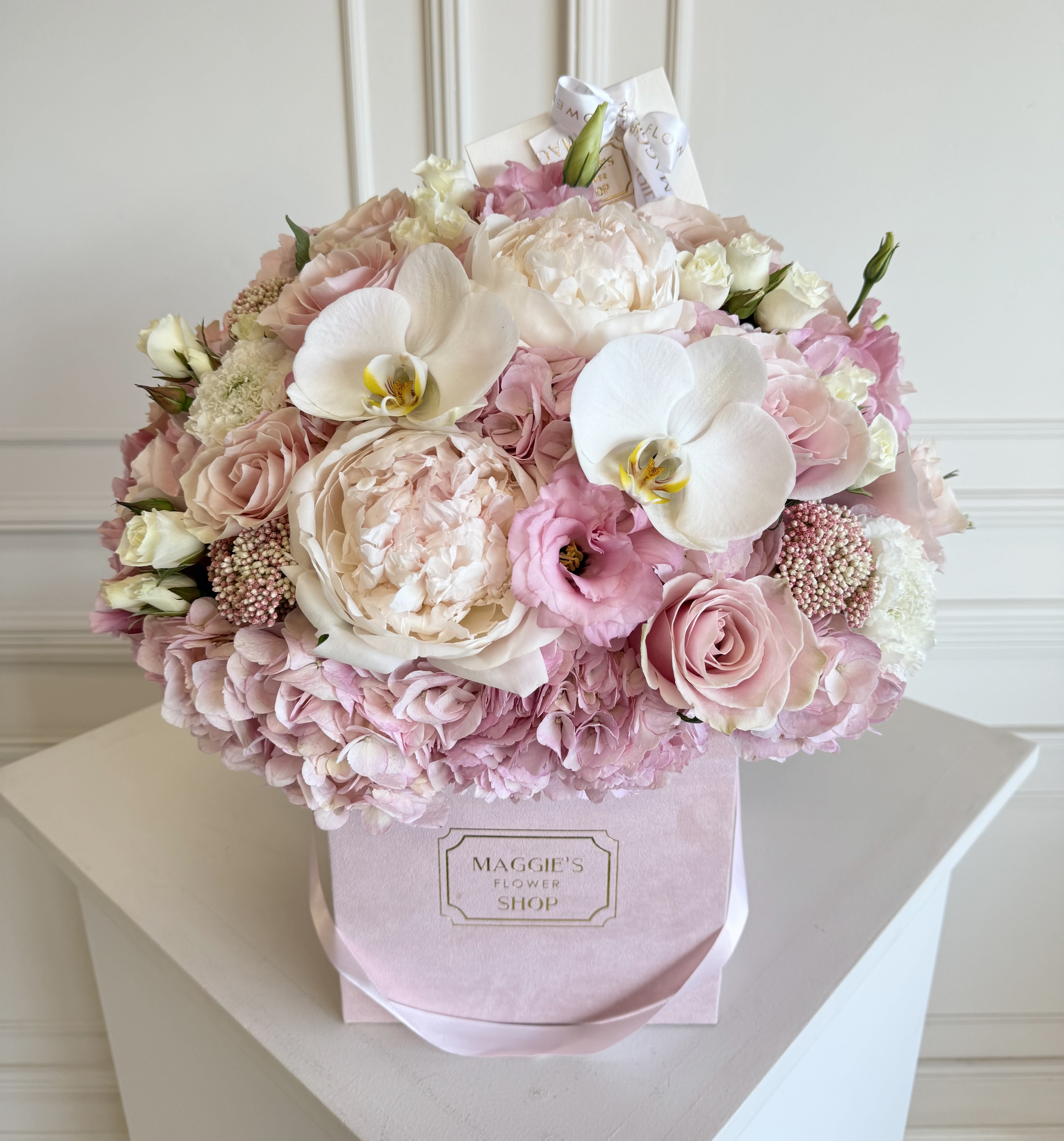 Pink and white bouquet in a pastel box with orchids and roses