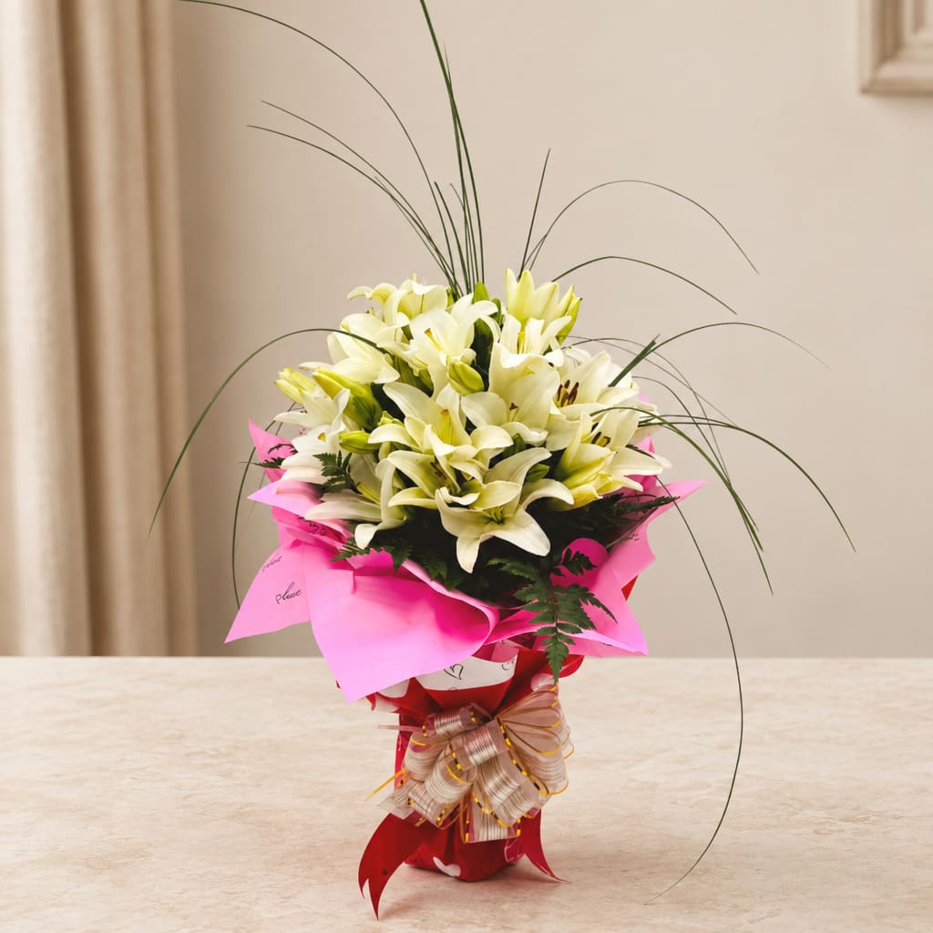 Bouquet of white lilies wrapped in bright pink paper with a ribbon