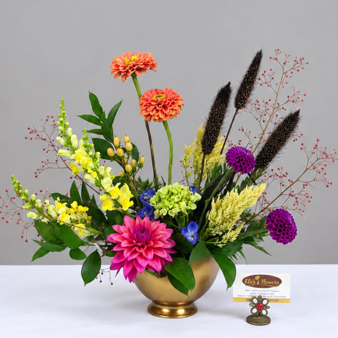 Colorful mixed flower arrangement in a gold bowl vase