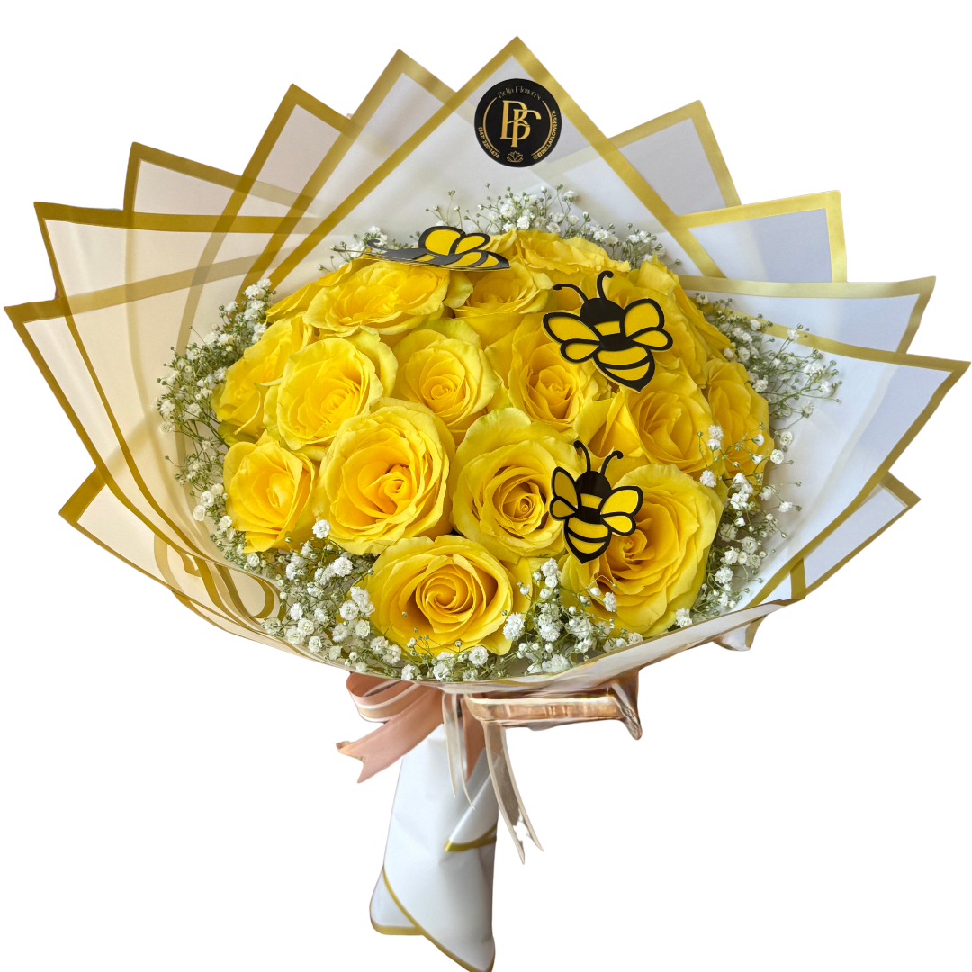 Yellow roses wrapped in white and gold paper with bee decorations