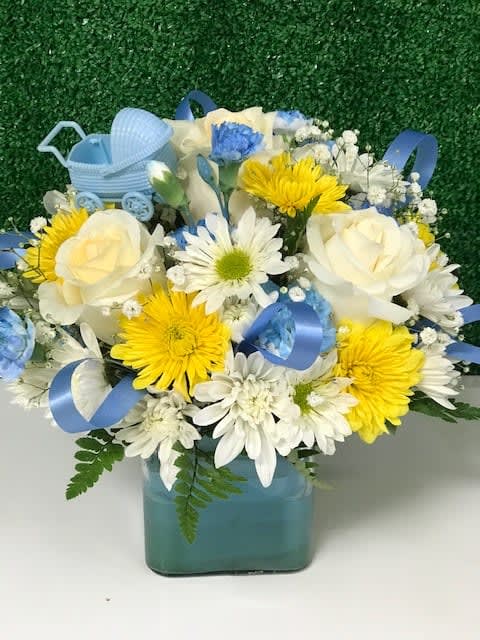 Blue and white flower arrangement in a square vase with a baby carriage decoration