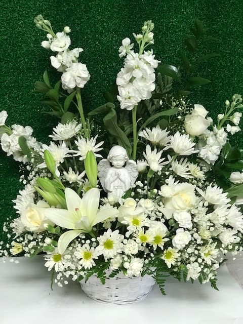 White floral basket with lilies, daisies, and an angel figurine