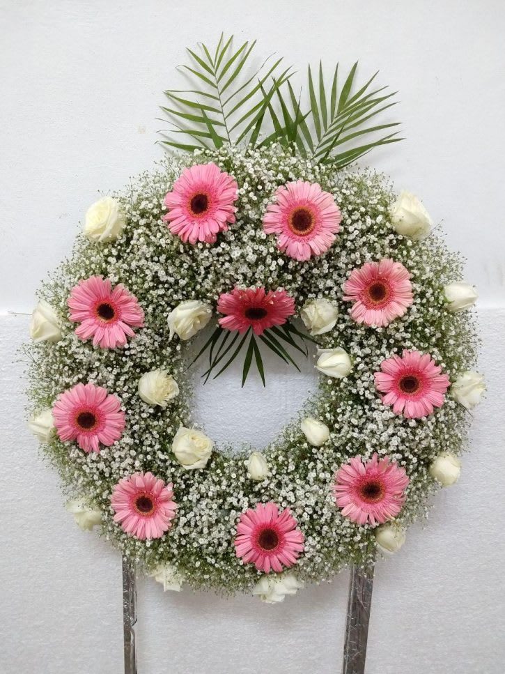 Pink gerbera daisy wreath with white roses and baby's breath