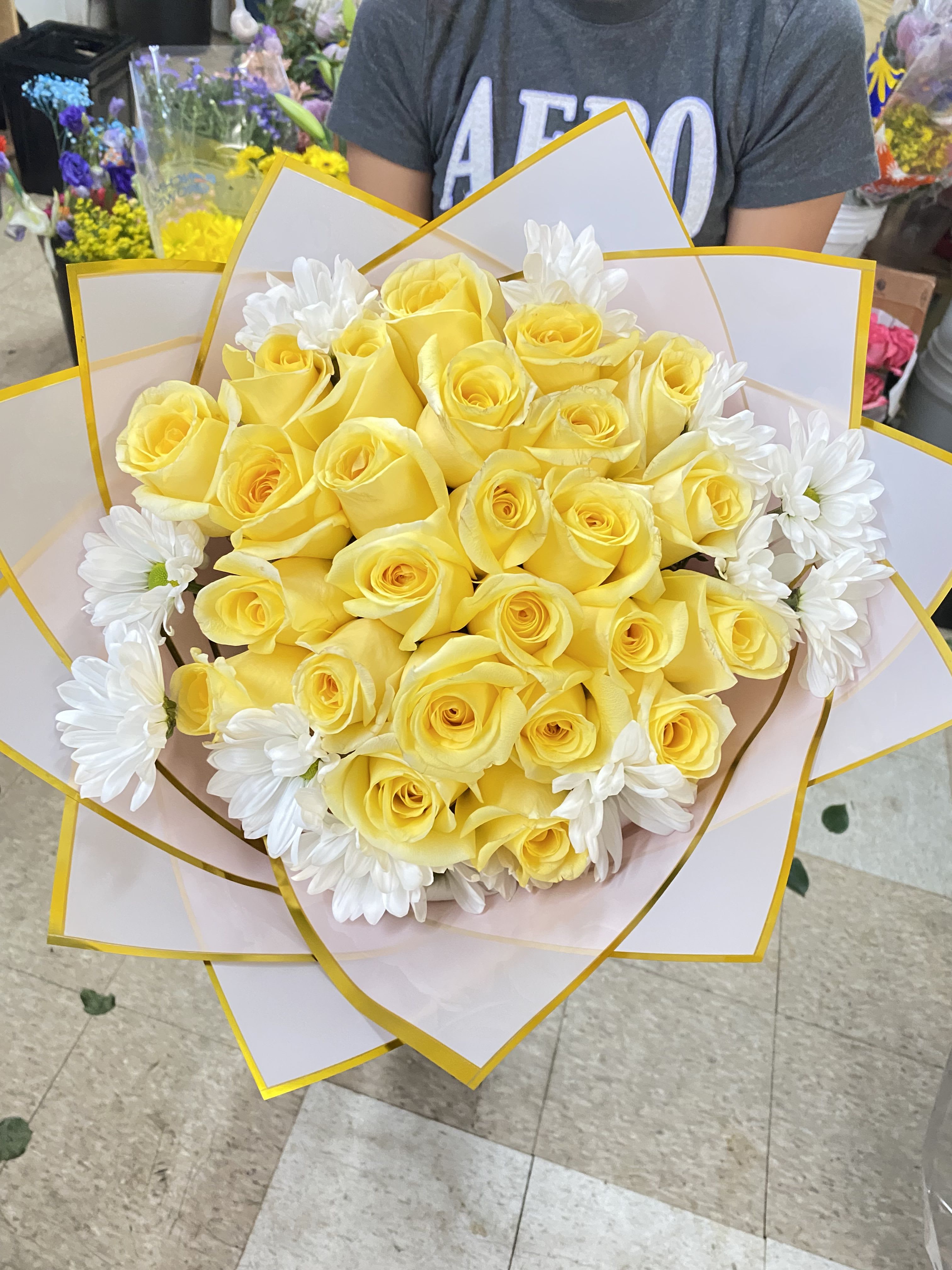 Yellow rose bouquet with white daisies wrapped in white paper